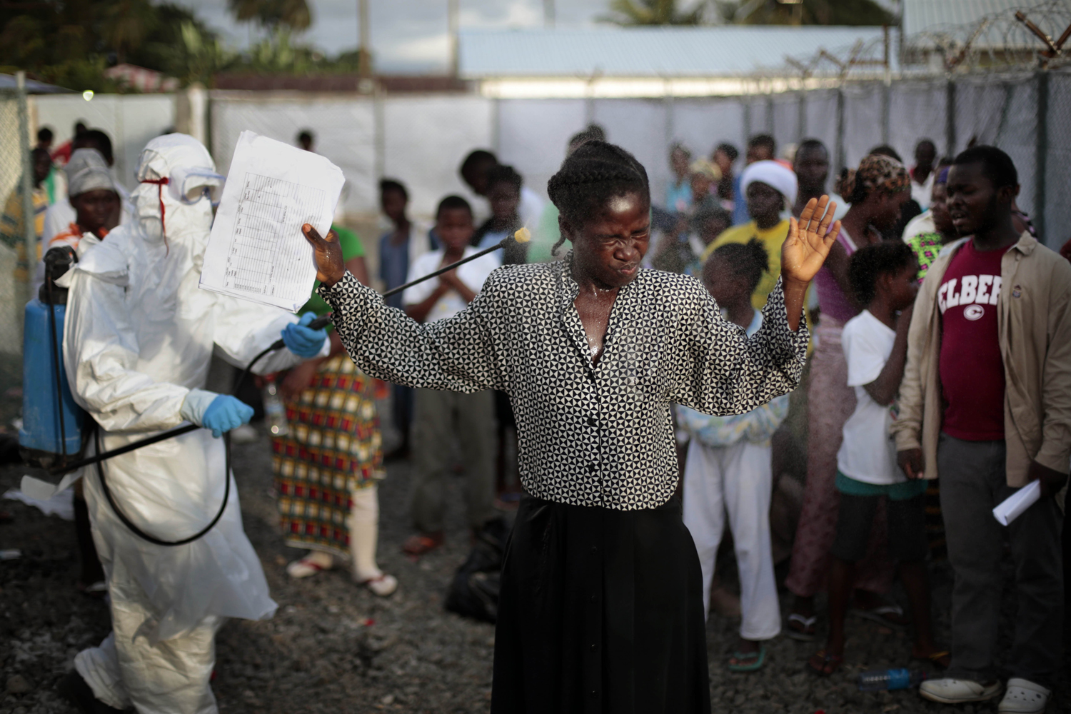 A woman being discharged from the Island Clinic Ebola treatment center in Monrovia, Liberia, is sprayed with disinfectant, Sept. 30, 2014.