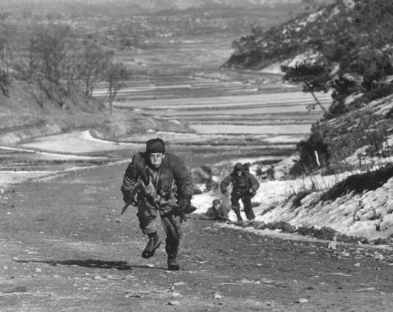 A rifleman dashes uphill to take cover from enemy fire, Korea, 1951.