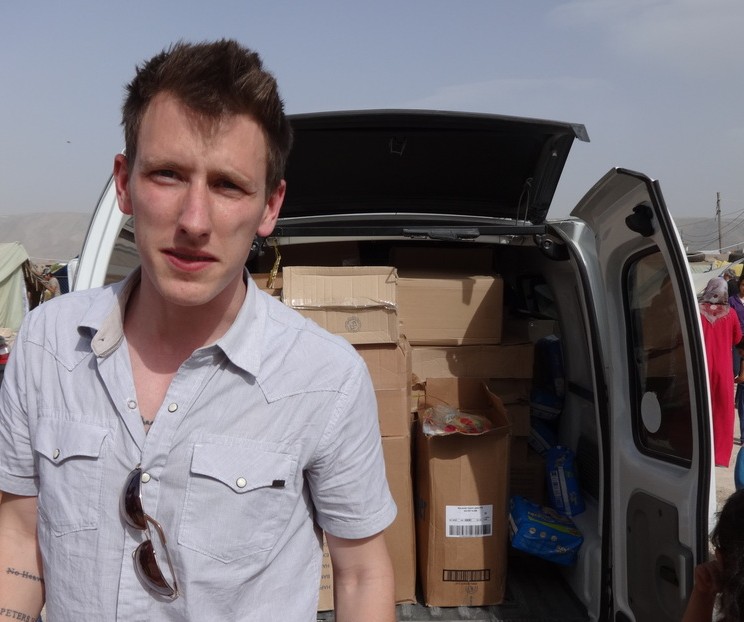 This undated photo provided by Kassig Family shows Peter Kassig standing in front of a truck filled with supplies for Syrian refugees. (AP)