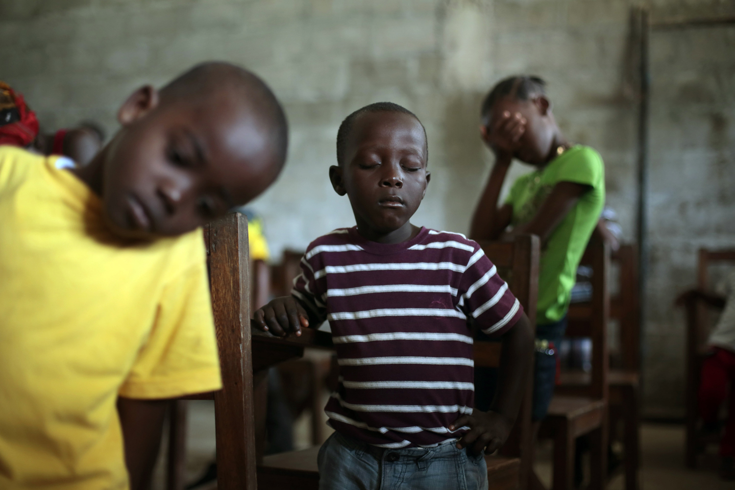 Children pray during Sunday service at the Bridgeway Baptist Church in the St. Paul Bridge neighborhood of Monrovia, Liberia, Sept. 28, 2014.