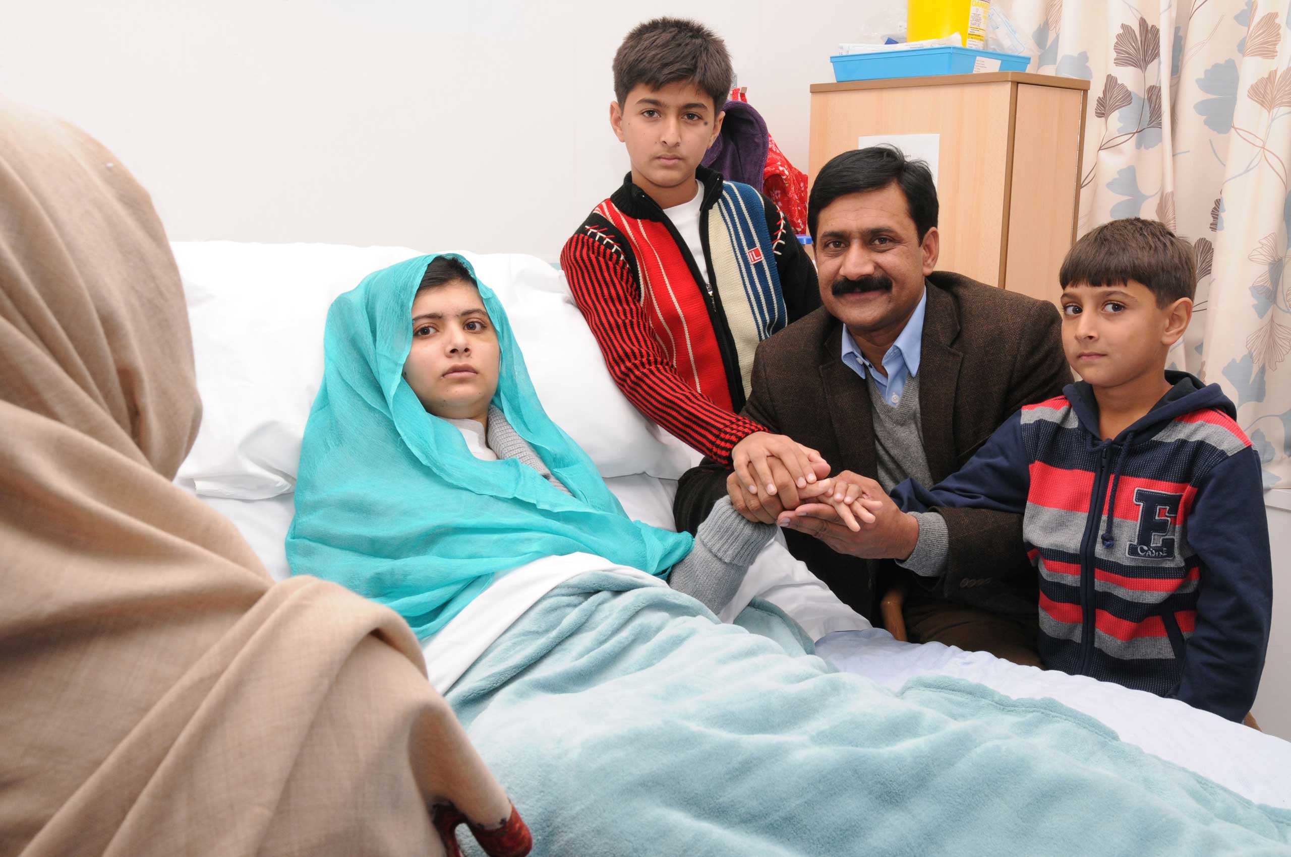 Malala Yousafzai sits up in her hospital bed with her father and her two younger brothers, on Oct. 26, 2012, in Birmingham, United Kingdom. The 15 year-old Malala was being treated after she was shot by the Taliban in Pakistan two weeks earlier.