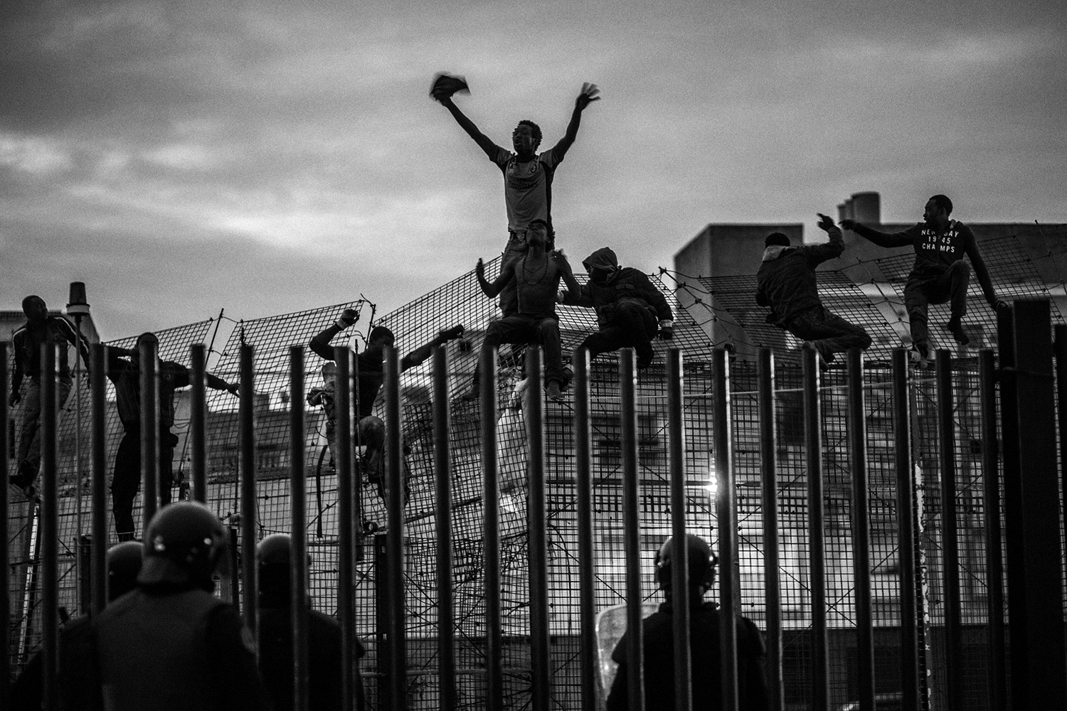 African migrants try to cross a border fence and enter the Spanish enclave of Melilla, March, 2014.