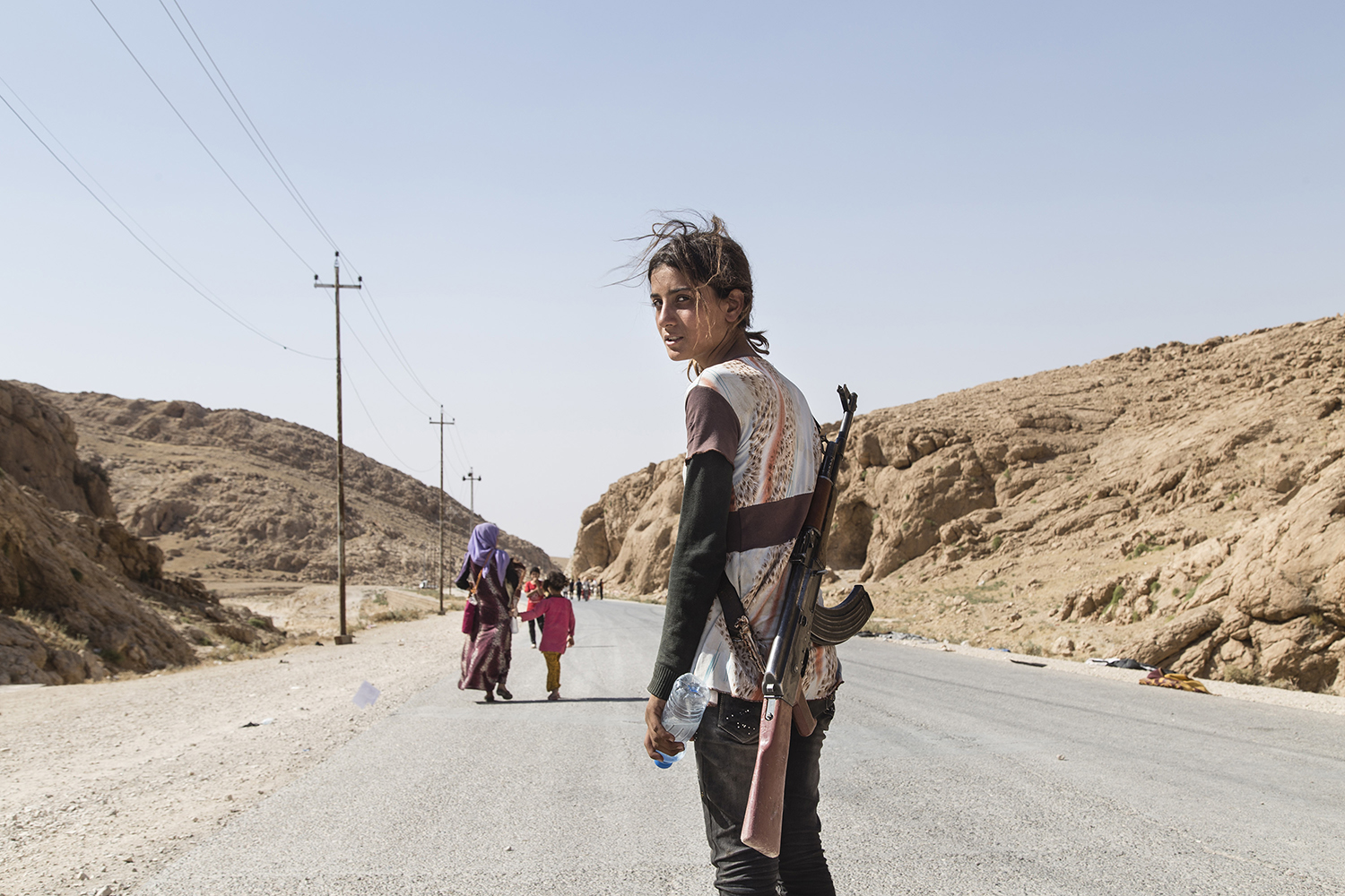 Runak,14, from Shengal, makes her way down the mountain after a week. August 2014. Sinjar Mountains, Iraq.