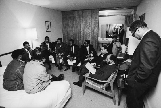 Stunned, silent members of the Southern Christian Leadership Conference in Dr. King's room at the Lorraine Motel, April 4, 1968, including Andrew Young (far left, under table lamp) and civil rights leader and Dr. King's colleague, Rev. Ralph Abernathy, in