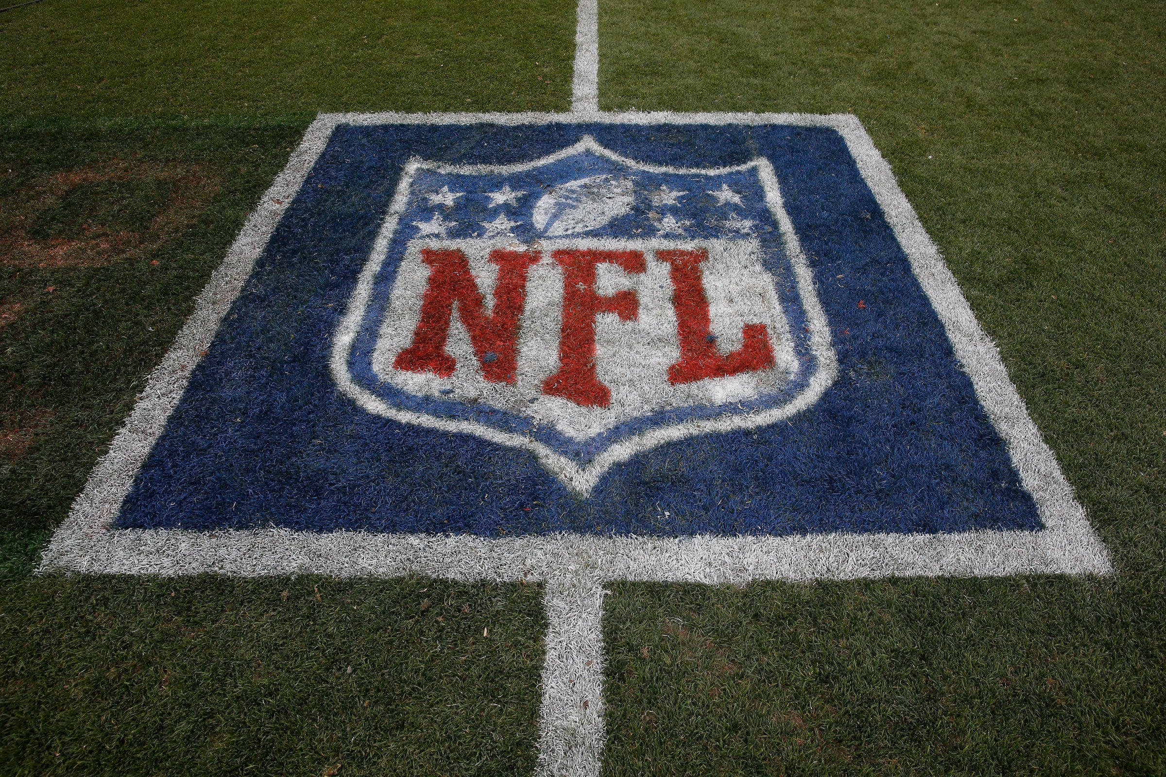 The NFL logo is displayed on the turf on September 14, 2014.