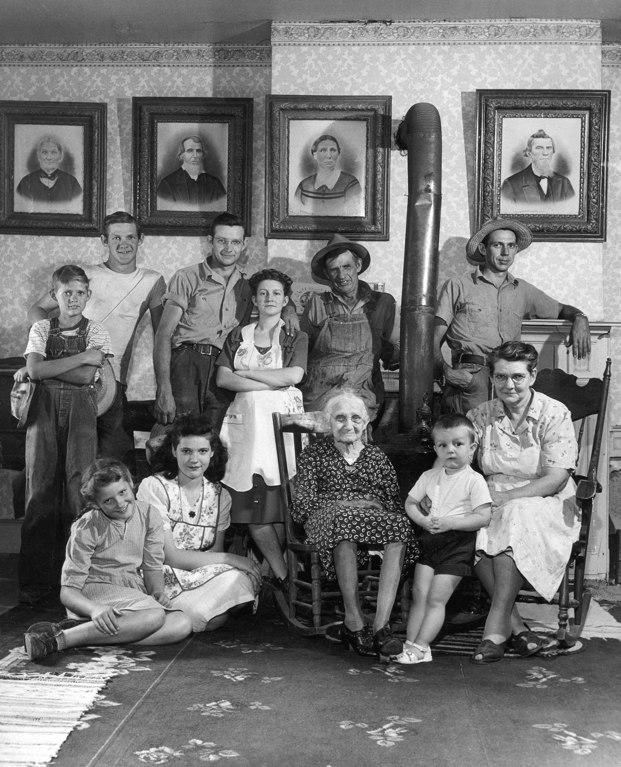 Caption that accompanied this picture in the July 26, 1948, issue of LIFE: "Four generations of the Russells gather for a portrait. The grandmother is 90, but she is still active. The portraits on wall at left are of old Mrs. Russell's parents, at right those at her late husband."