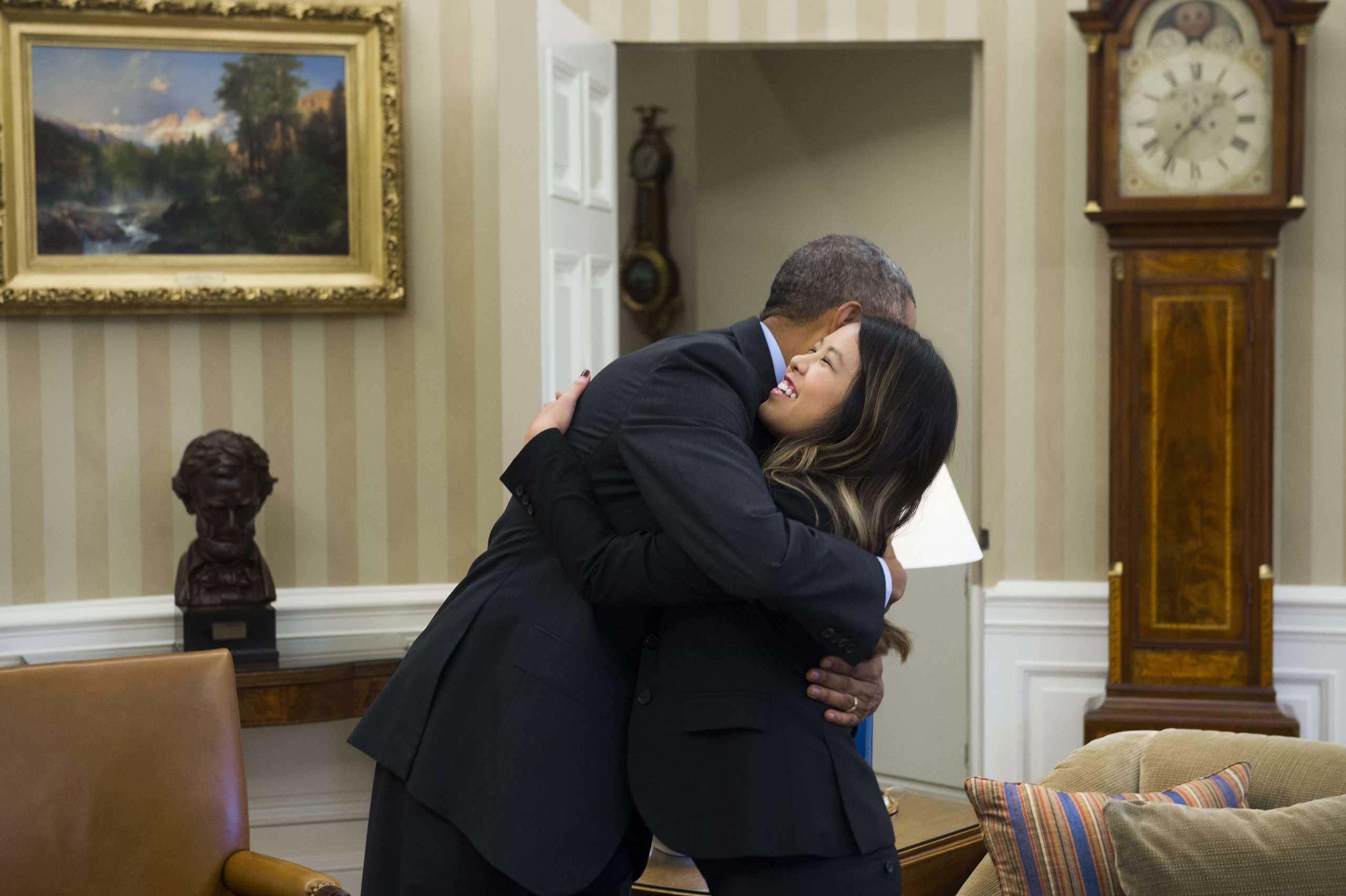 President Barack Obama hugs nurse Nina Pham, who was declared free of the Ebola virus after contracting the disease while caring for a Liberian patient in Texas, during a meeting in the Oval Office in Washington on Oct. 24, 2014.