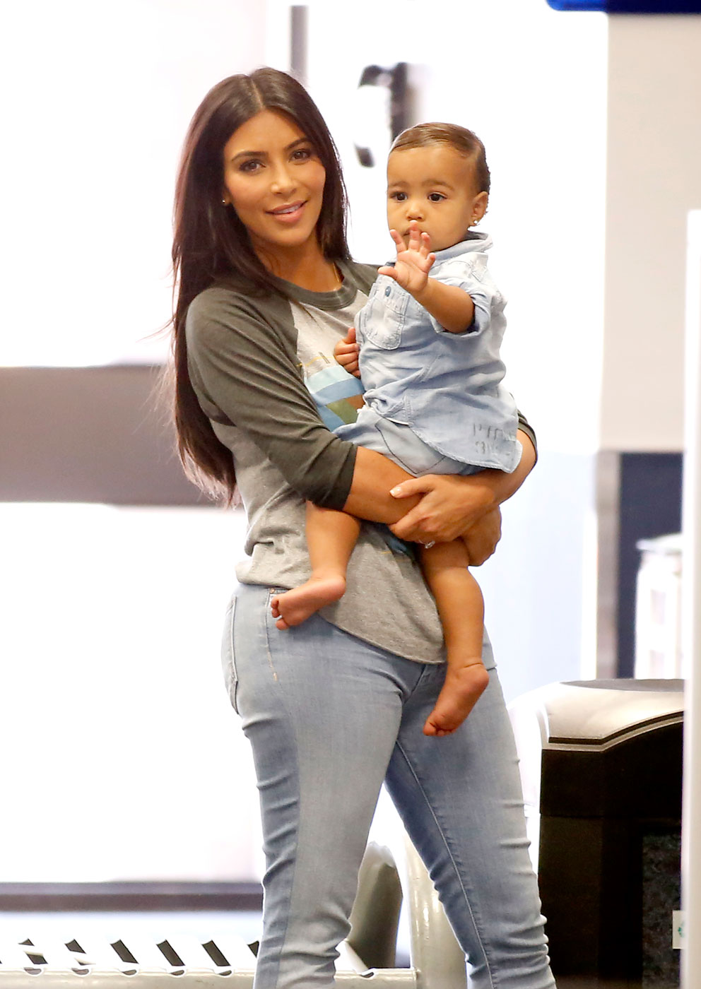 Kim Kardashian holds her 14-month-old daughter, North West as they make their way through Burbank Airport in Los Angeles on Aug. 7, 2014.