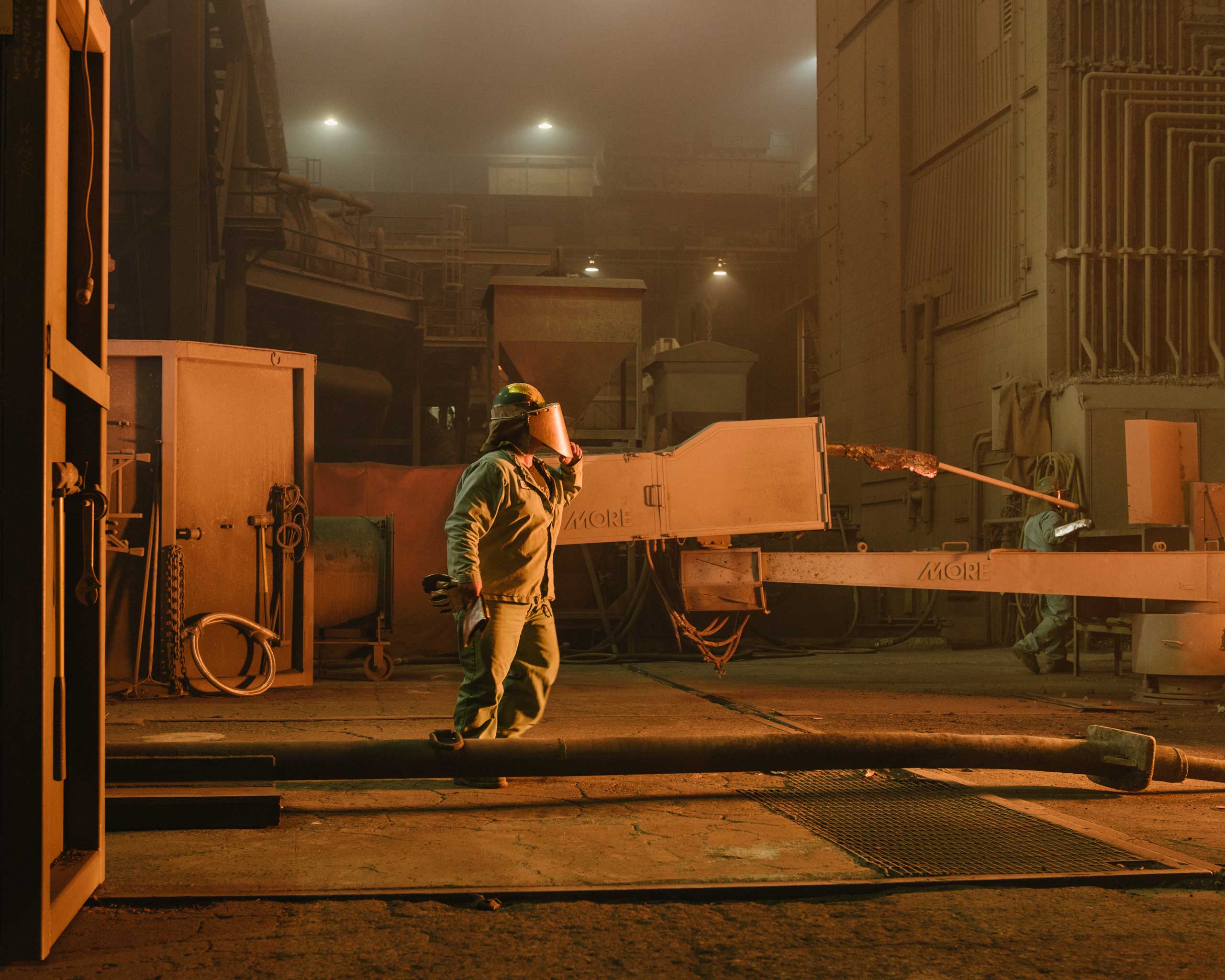 A worker approaches the electric-arc furnace, which uses three giant
                      electrodes to melt scrap into molten steel. Nucor's workers are among the
                      highest-paid in the industry, Crawfordsville, Ind. on Aug. 25, 2014. (Ryan Lowry for TIME)