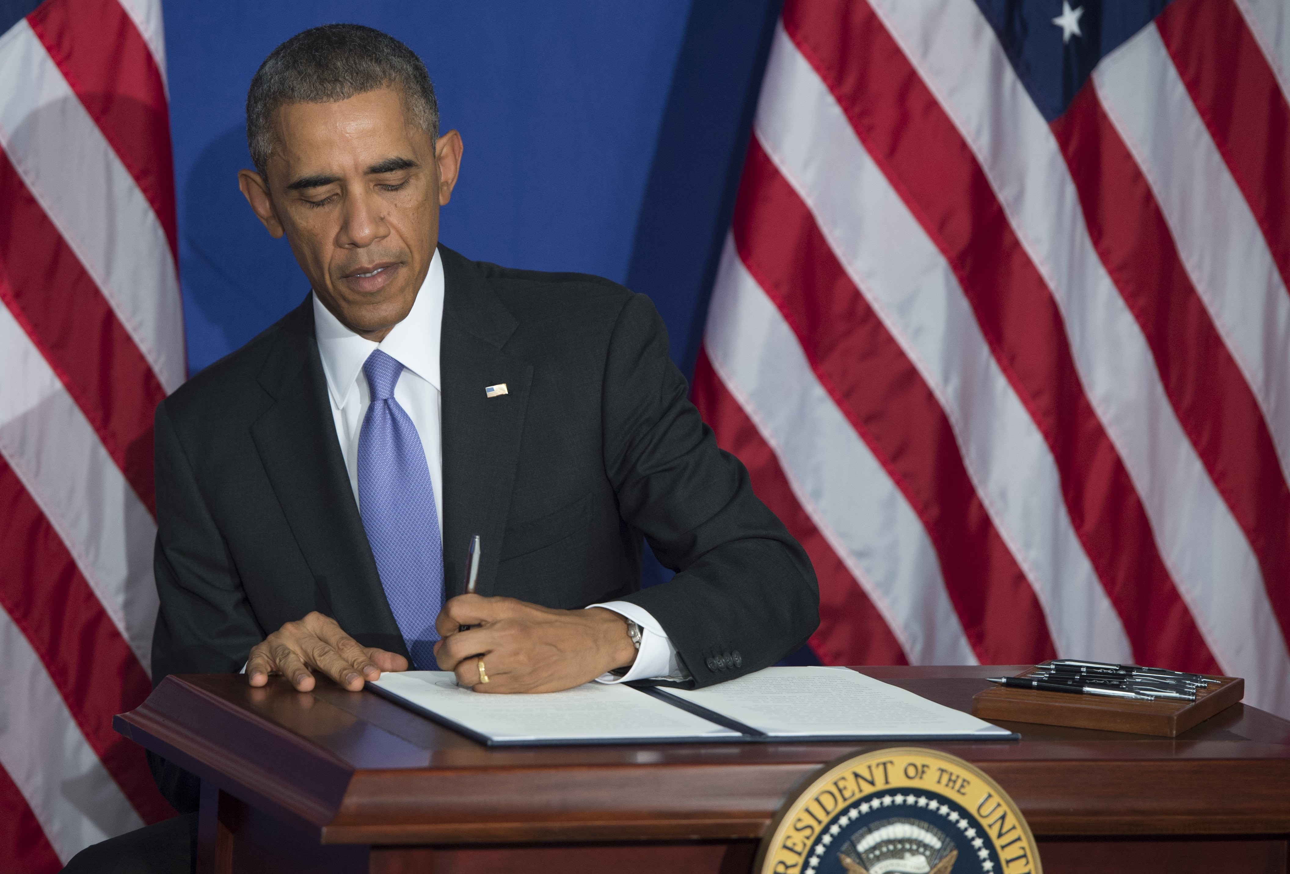 President Barack Obama signs an Executive Order to implement enhanced security measures on consumers' financial security following remarks at the Consumer Financial Protection Bureau (CFPB) in Washington, DC, October 17, 2014. (SAUL LOEB&mdash;AFP/Getty Images)