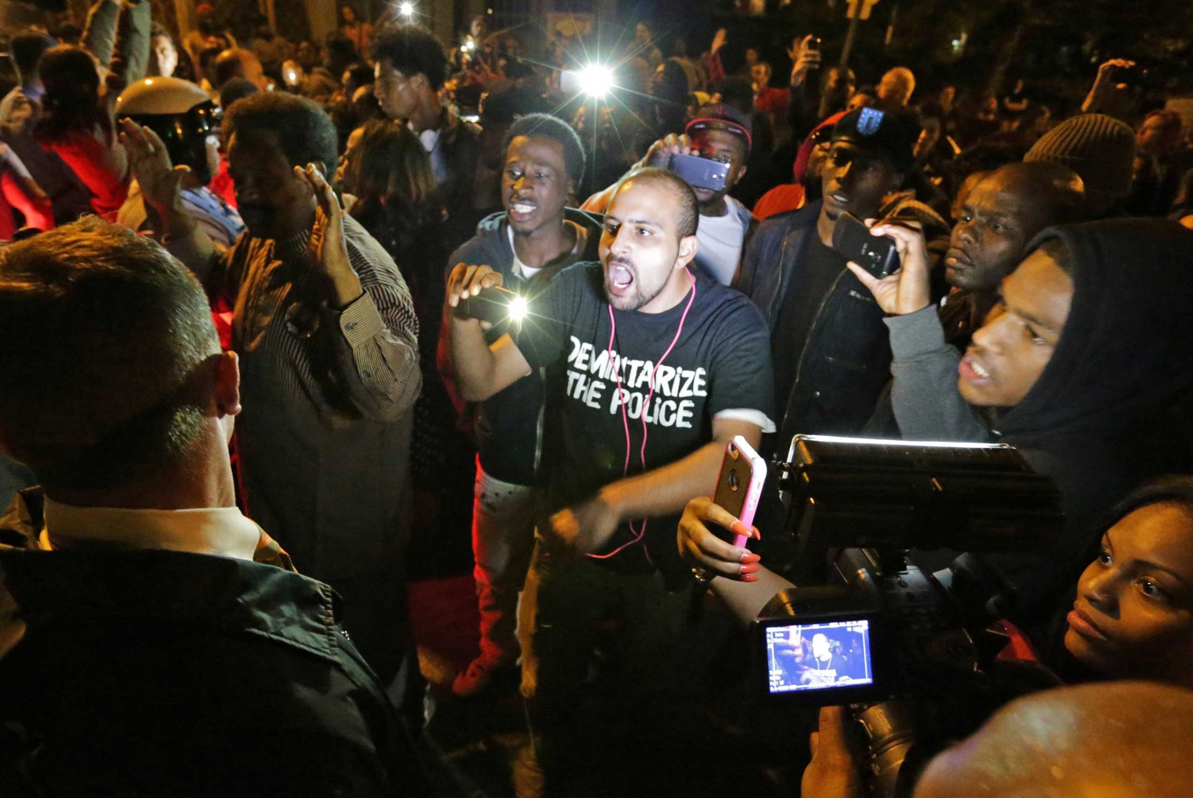 Crowds confront police near the scene in in south St. Louis where a man was fatally shot by an off-duty St. Louis police officer on Oct. 8, 2014. St. Louis.