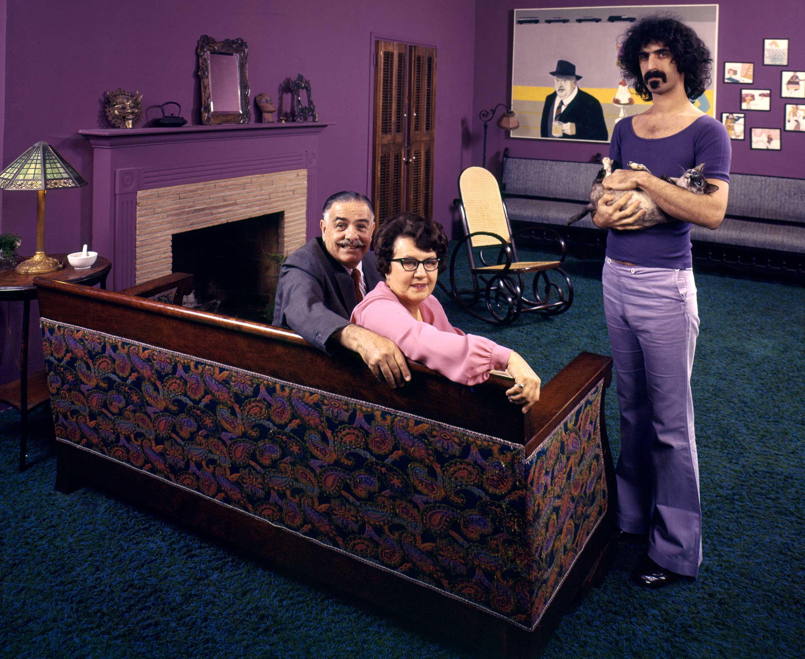Frank Zappa in his Los Angeles home with his dad, Francis, his mom, Rosemarie, and his cat in 1970.