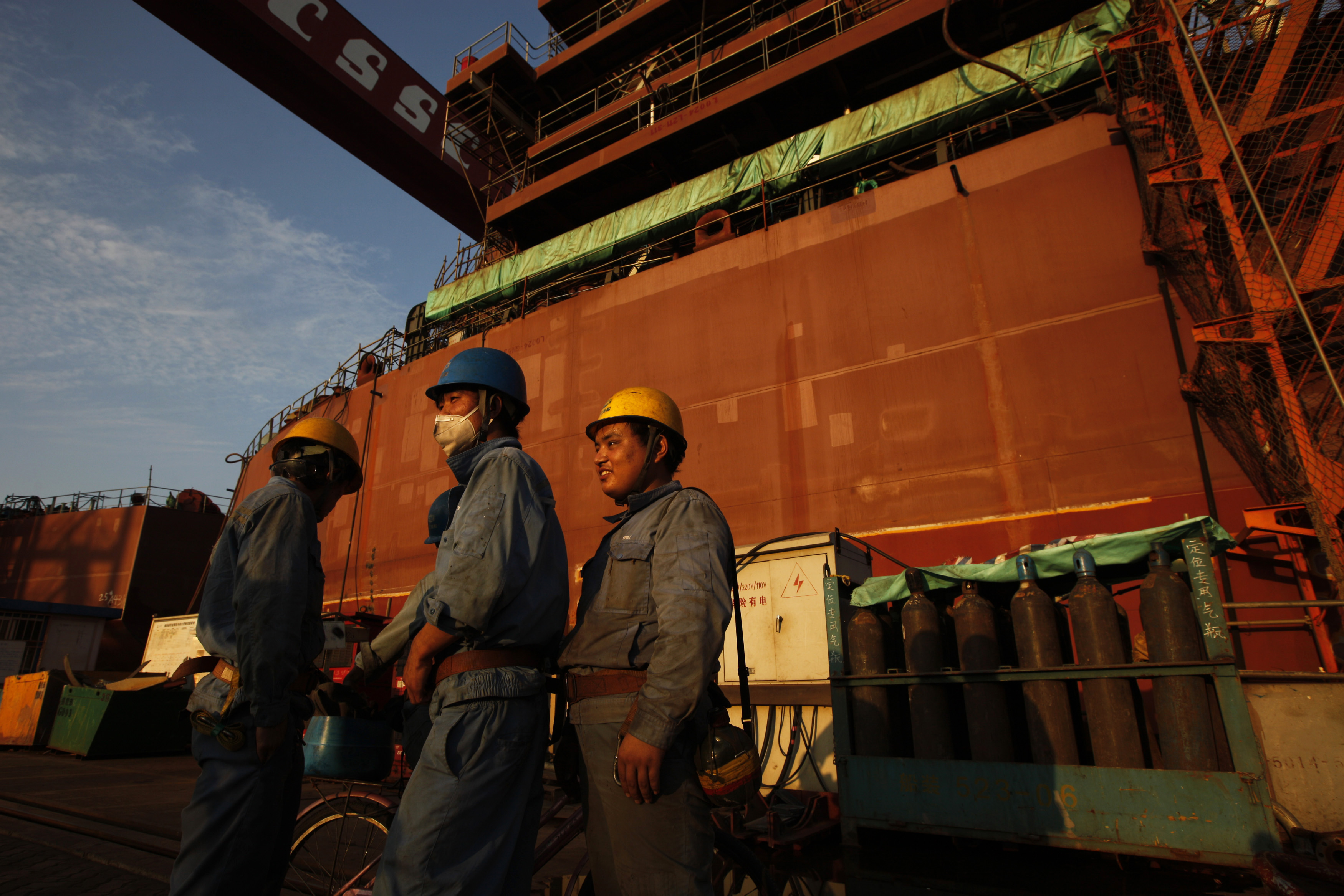 Employees stand in front of nearly completed ship at China State Shipbuilding Corporation (CSSC) Longxue shipbuilding, in the southern Chinese city of Guangzhou November 13, 2011. (© Siu Chiu / Reuters—REUTERS)