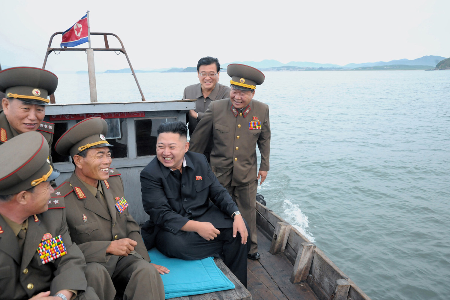 North Korean leader Kim Jong-Un sits in a wooden boat with other soldiers as he visits military units on islands in the most southwest of Pyongyang