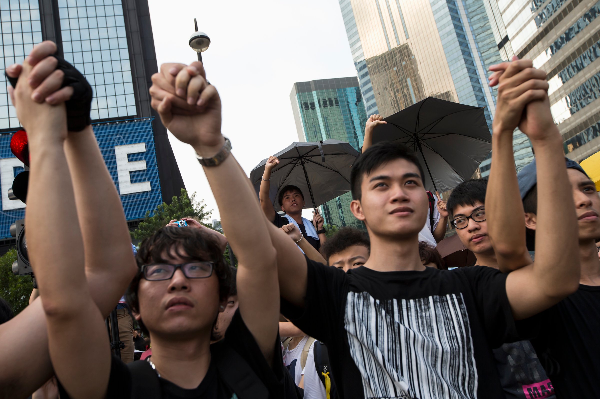 Student protesters gesture outside the Golden Bauhinia Square, venue of the official flag-raising ceremony for celebrations of China's National Day in Hong Kong