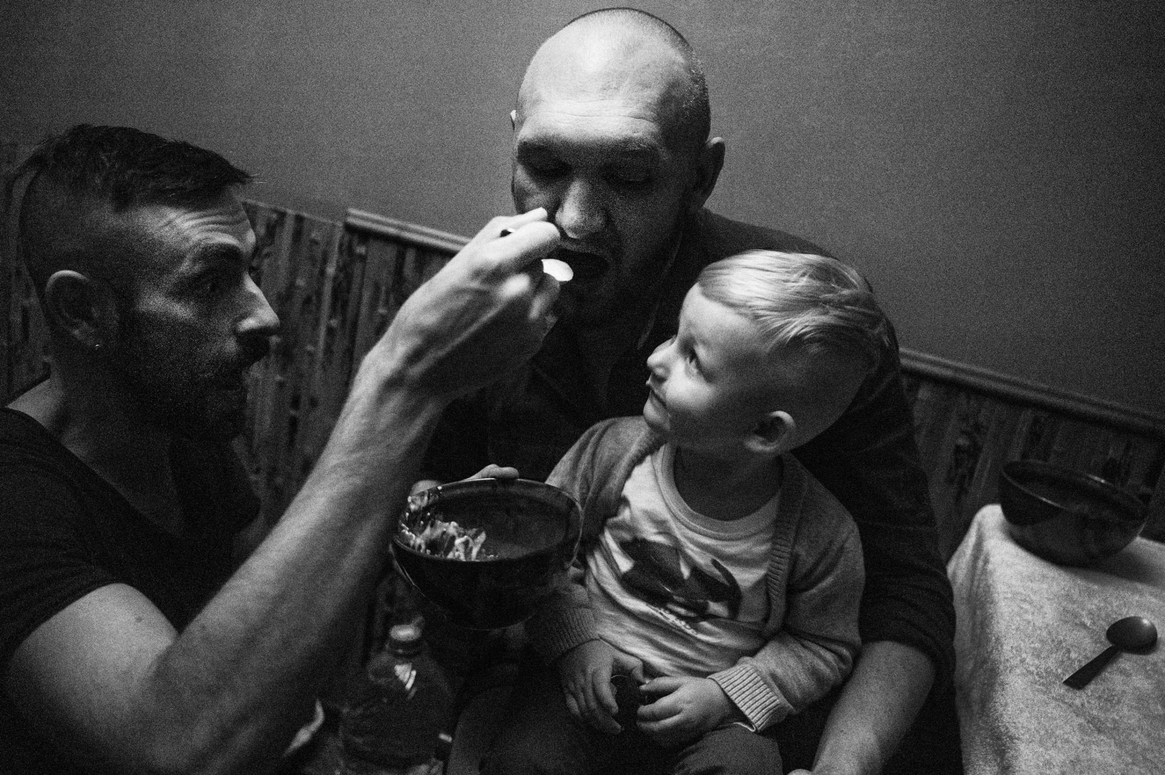 Bogdan is feeding Yegor, trying to convince Timur to eat his dinner.