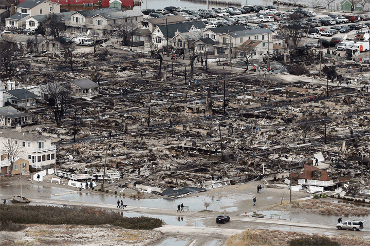 Before: The remains of burned homes in the Breezy Point neighborhood of Queens on October 31, 2012. After: Newly built homes and vacant lots in Breezy Point on October 21, 2013.
