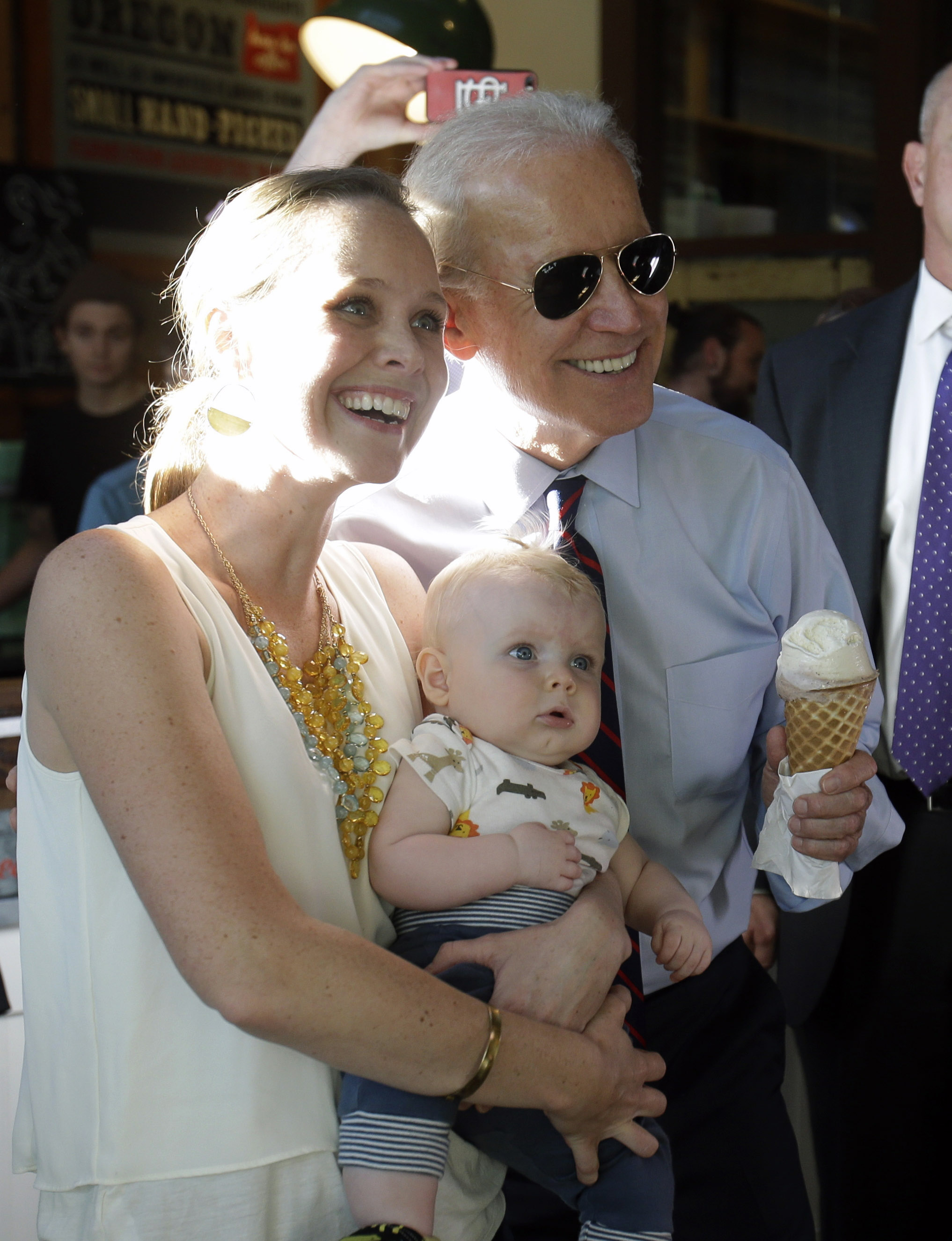 Vice President Joe Biden holds an ice cream cone as he poses for a photo with Hope Lobkowizc and her son, Owen, at an ice cream parlor after a campaign rally in Portland, Ore., Wednesday, Oct. 8, 2014. (Don Ryan—AP)