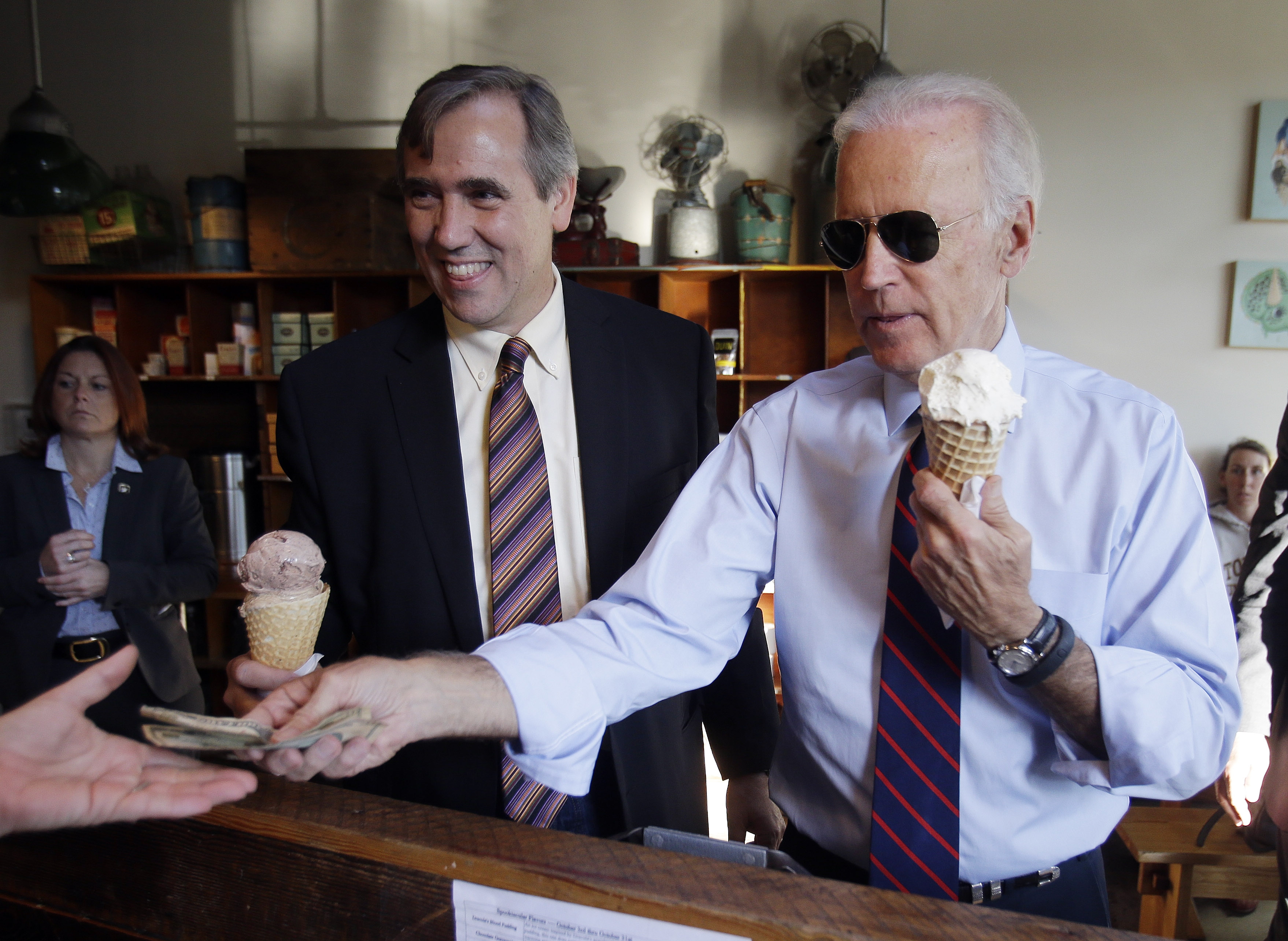 Vice President Joe Biden, right, pays for ice cream cones for himself and U.S. Sen. Jeff Merkley after a campaign rally in Portland, Ore., Wednesday, Oct. 8, 2014. (Don Ryan—AP)