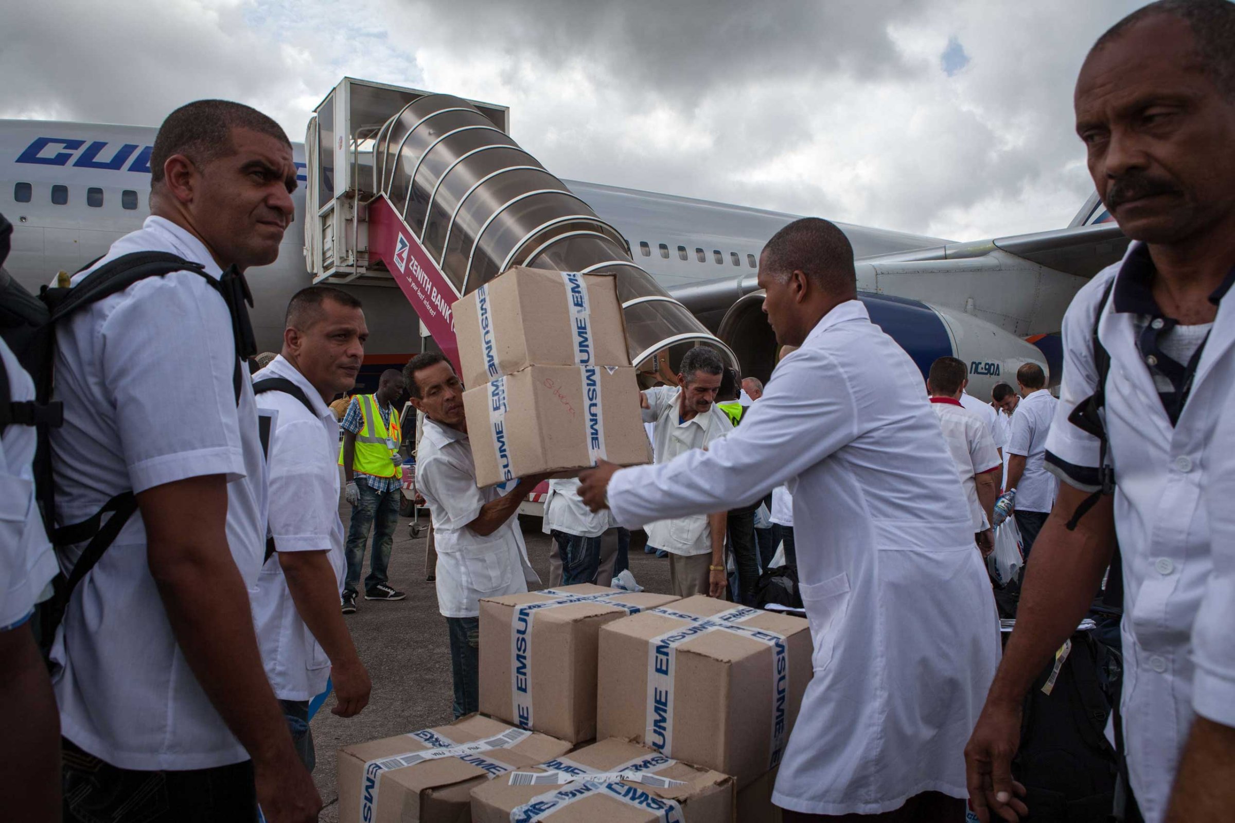 Cuban doctors and health workers unload boxes of medicines and medical material from a plane upon their arrival at Freetown's airport to help the fight against Ebola in Sierra Leone, on Oct. 2, 2014.
