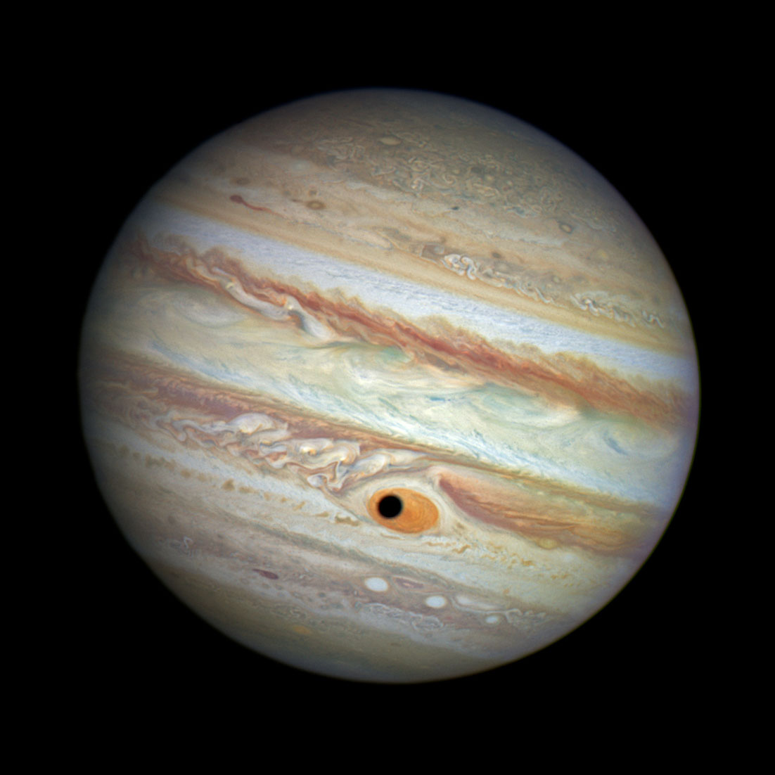 Jupiter's Giant Eye On April 21, 2014, when Hubble was being used to monitor changes in Jupiter's immense Great Red Spot (GRS) storm, the shadow of the Jovian moon Ganymede swept across the center of the GRS giving the giant planet the appearance of having a pupil in the center of a 10,000-mile-diameter  eye.