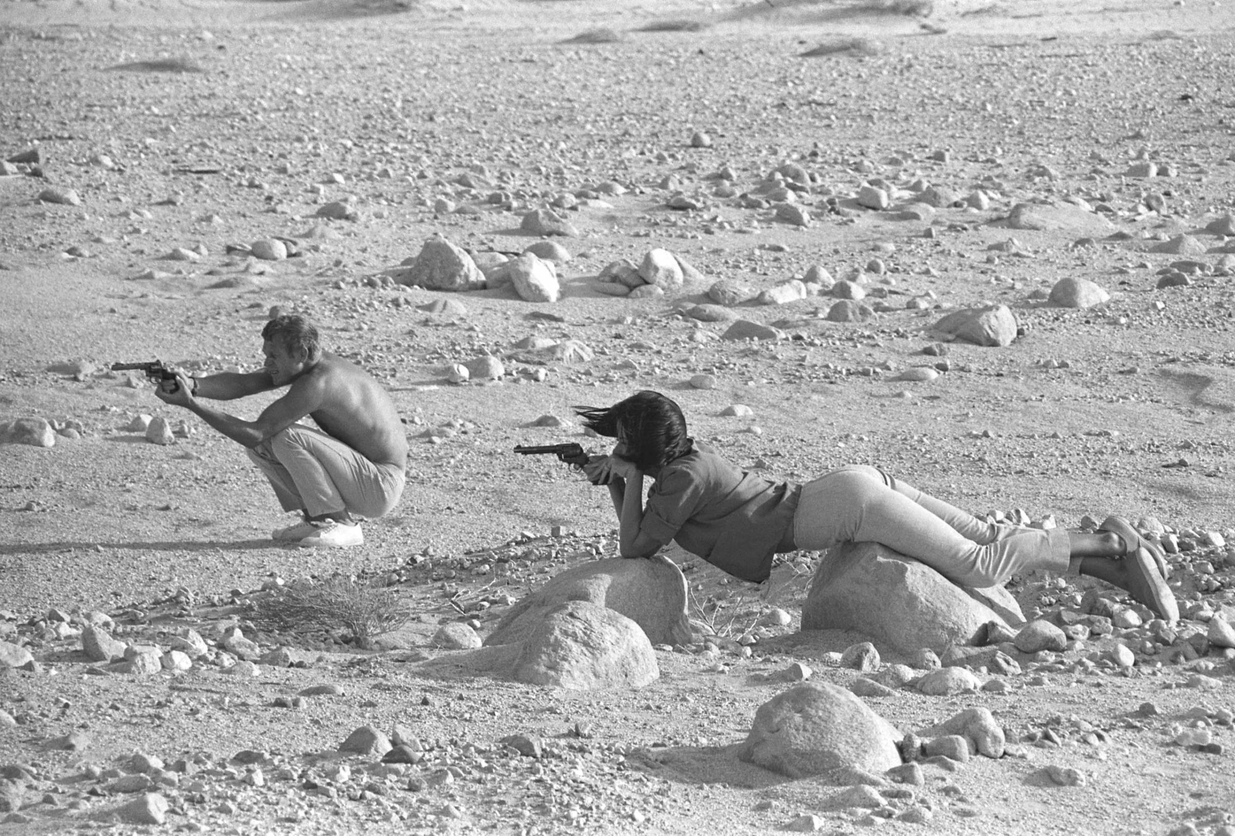 Steve McQueen and Neile Adams, his first wife, target-practice with their pistols in the California desert, 1963.