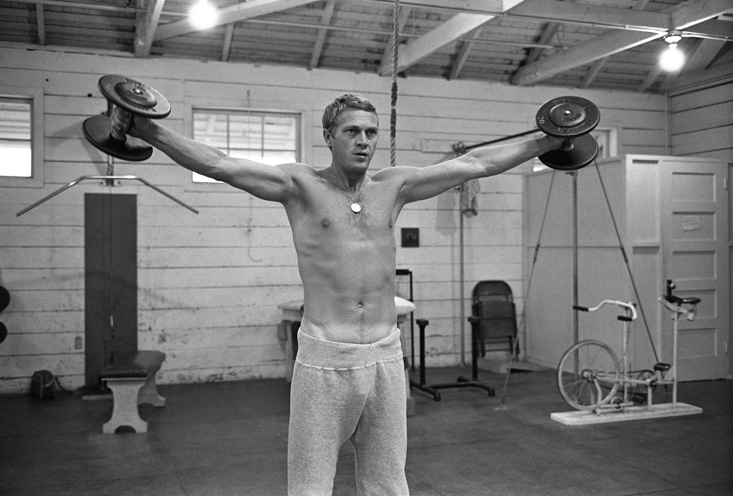 Steve McQueen lifts weights, 1963.