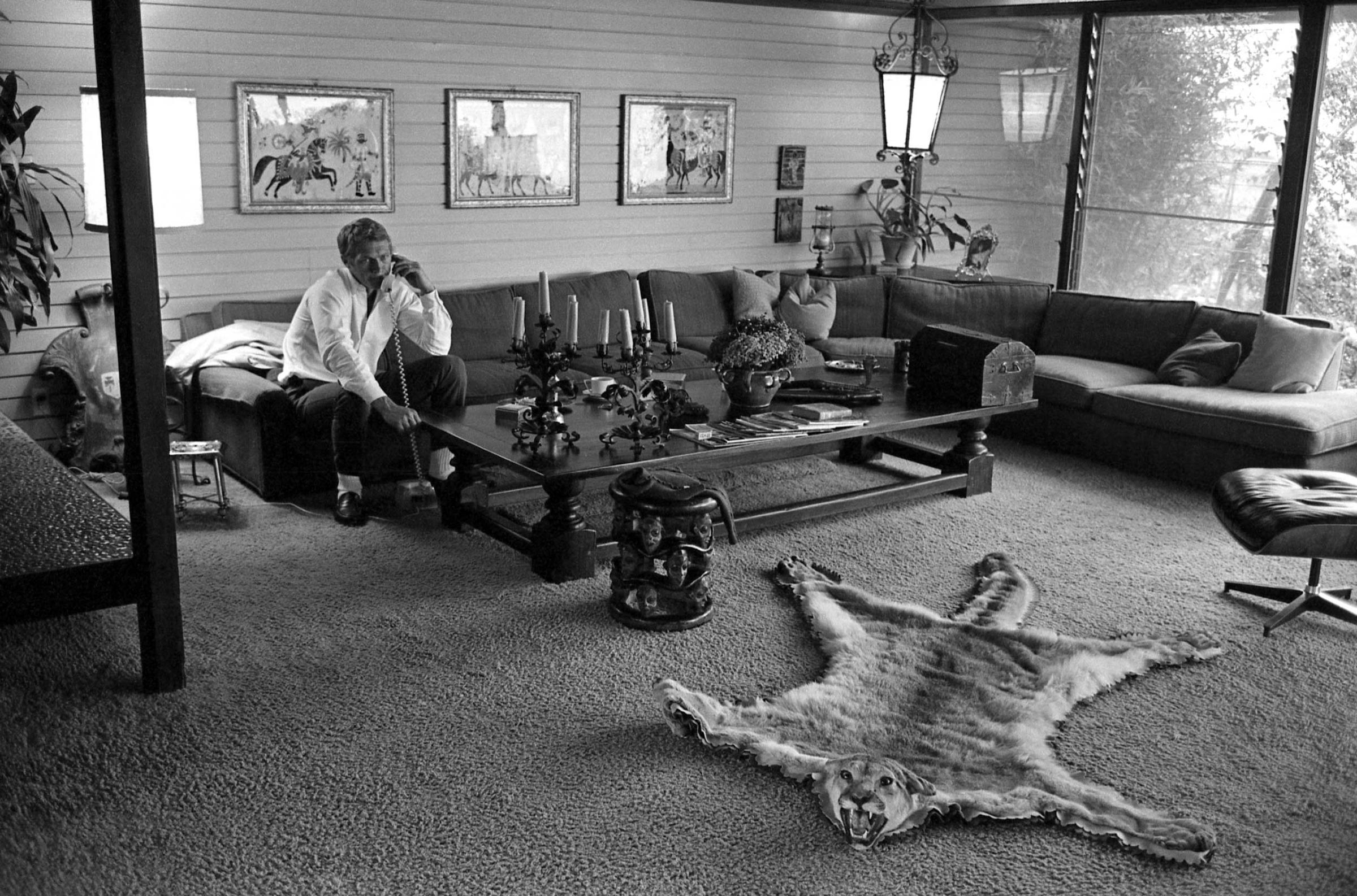 McQueen takes a call in the living room of his eclectic home in Hollywood, 1963.