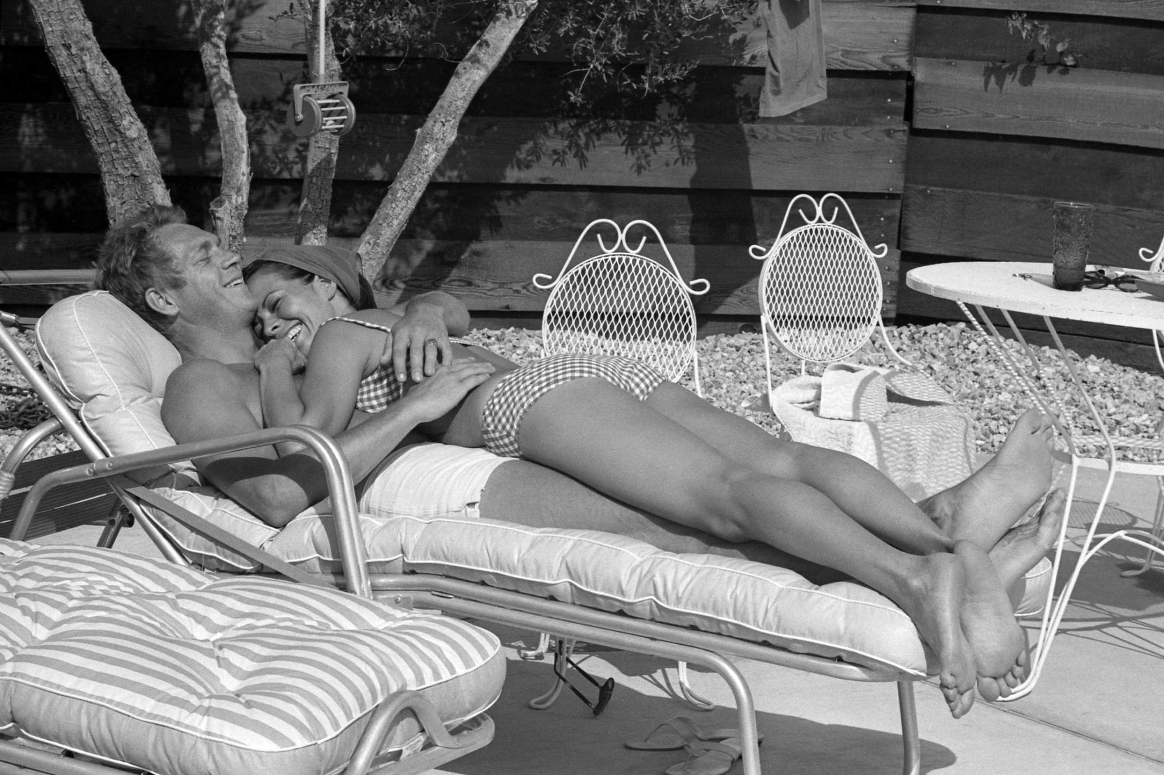 Steve McQueen and his wife Neile Adams lounge on the patio by the pool at their Palm Springs bungalow, 1963.
