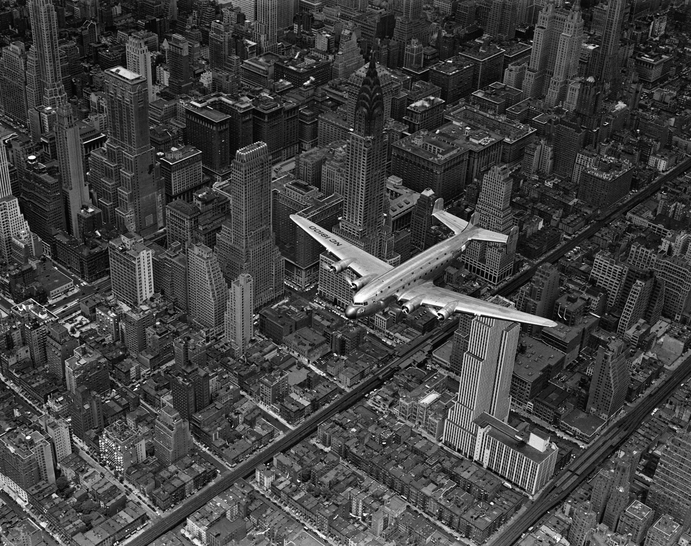 Aerial view of a DC-4 passenger plane flying over midtown Manhattan. An almost identical photograph from this shoot was published in the June 19, 1939, issue of LIFE.