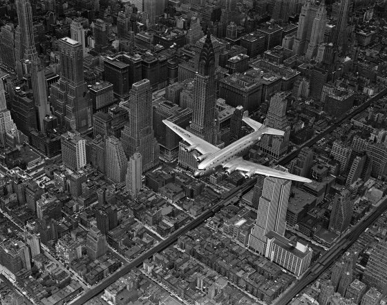 Aerial view of a DC-4 passenger plane flying over midtown Manhattan. An almost identical photograph from this shoot was published in the June 19, 1939, issue of LIFE.