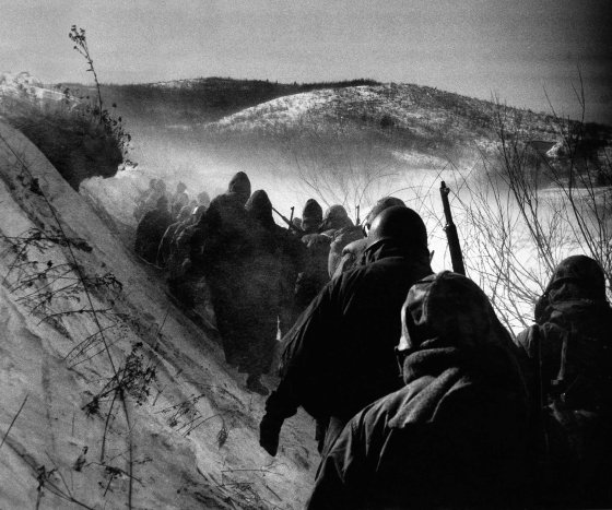 Early in the Korean War, American Marines march through bitter cold down a canyon road they dubbed 