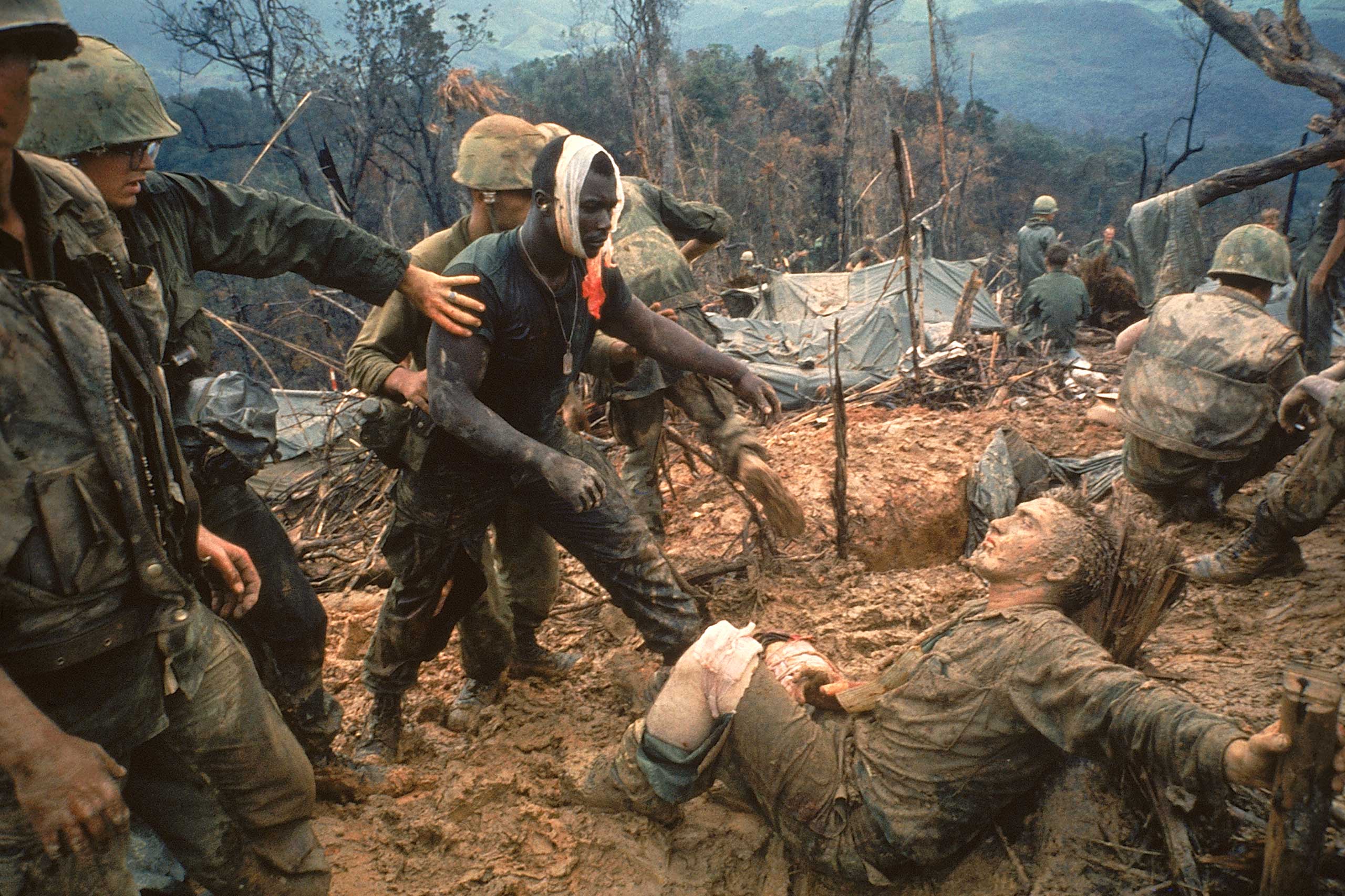 1966 | Wounded Marine Gunnery Sgt. Jeremiah Purdie (center) moves to try and comfort a stricken comrade after a fierce firefight during the Vietnam War. Photographed for an essay that ran in the October 28, 1966, issue of LIFE, this Larry Burrows picture — now regarded as one of the handful of utterly indispensable images from the war — did not appear in the magazine until February 1971.