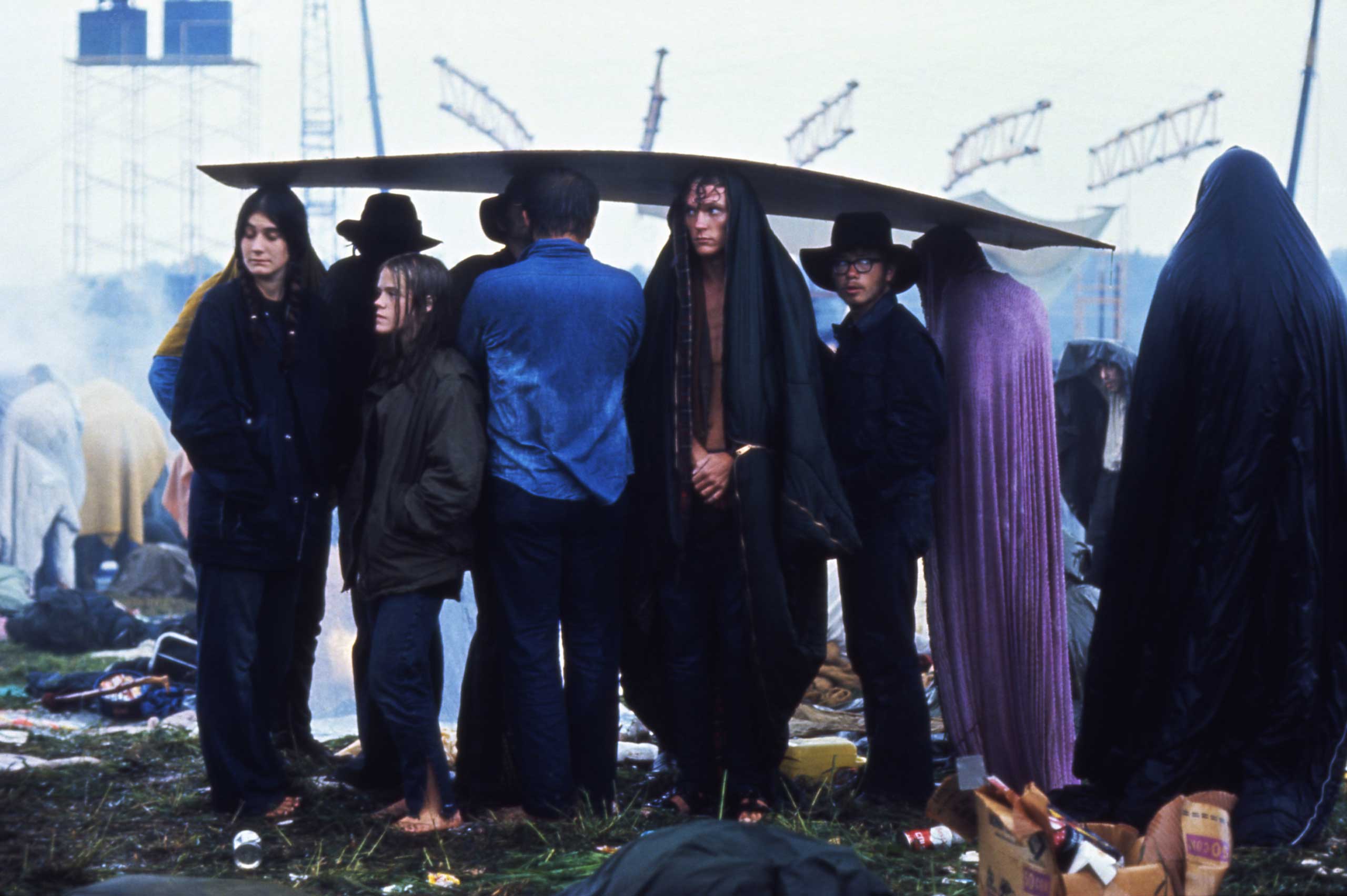 1969 | Concert-goers huddle under a sheet of cardboard in the rain at the three-day, era-defining Woodstock Music and Art Fair in Bethel, New York. Originally published in the August 29, 1969, issue of LIFE.