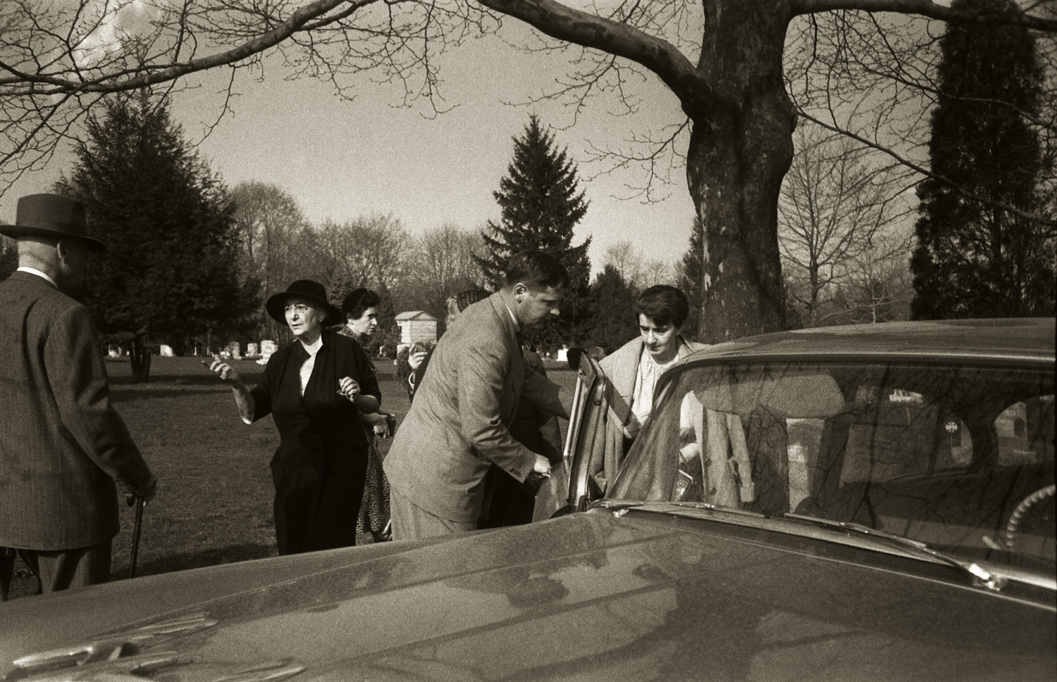 An unidentified man holds a car door open for Albert Einstein's secretary, Helen Dukas, following Einstein's cremation, April 1955.