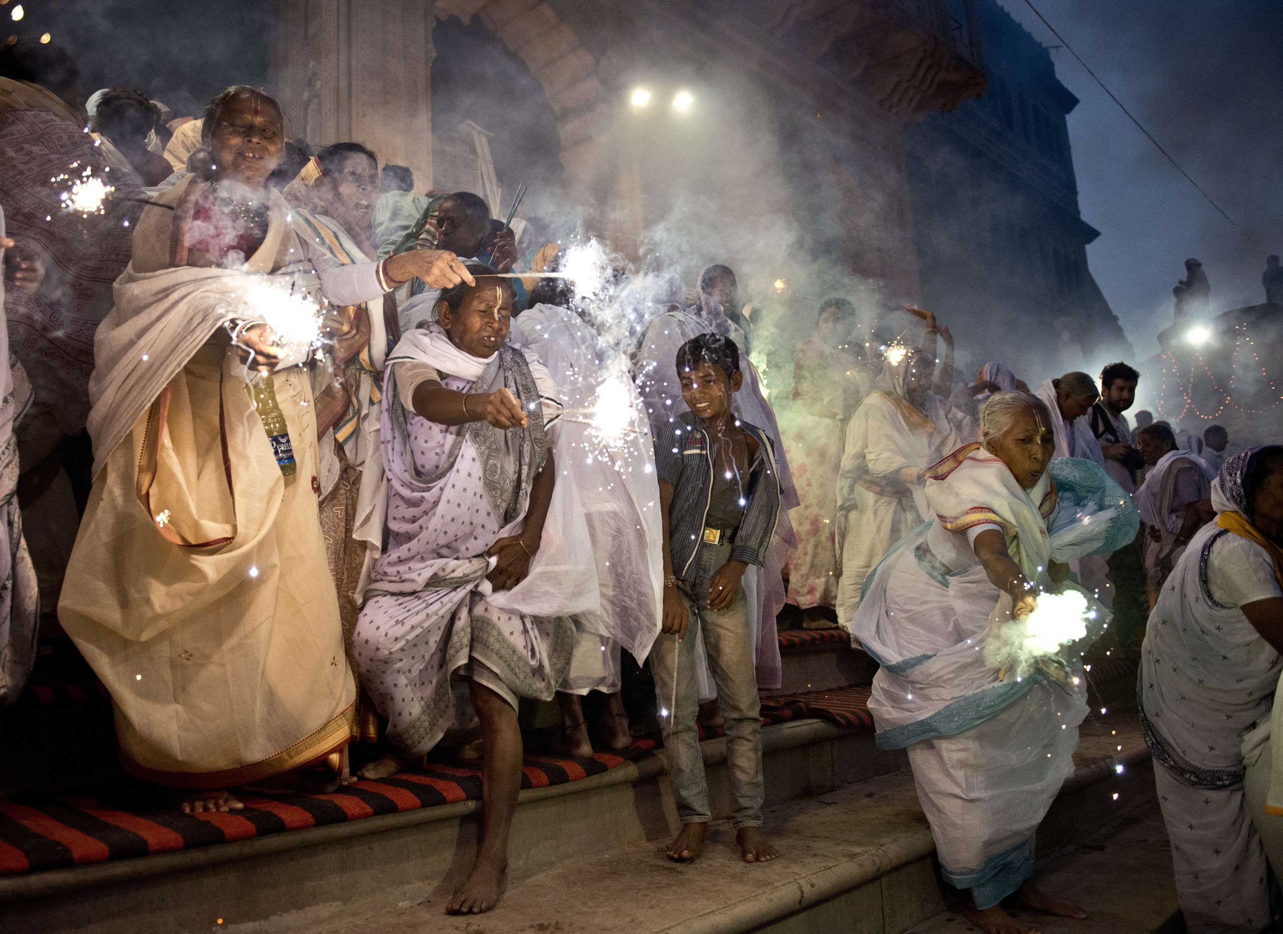 Oct. 21, 2014. Indian widows wave sparklers as they participate in a celebration for the Hindu festival Diwali on the banks of the Yamuna river in the northern city of Vrindavan.