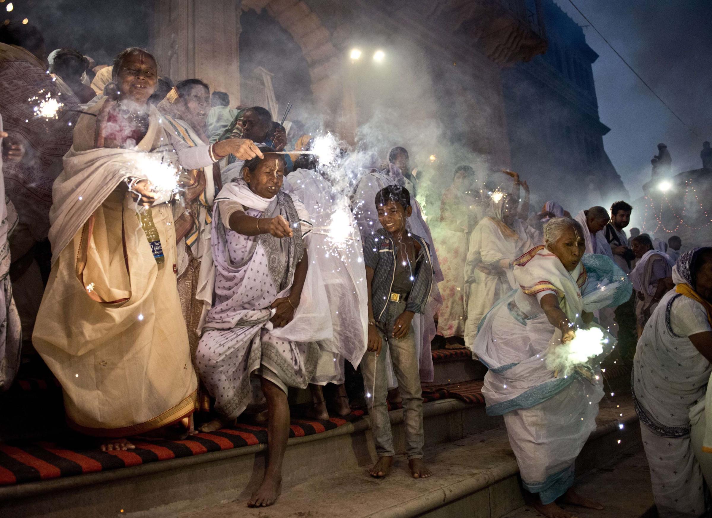 Indian widows wave sparklers as they participate in a celebration for the Hindu festival Diwali on the banks of the Yamuna river in the northern city of Vrindavan on Oct. 21, 2014.