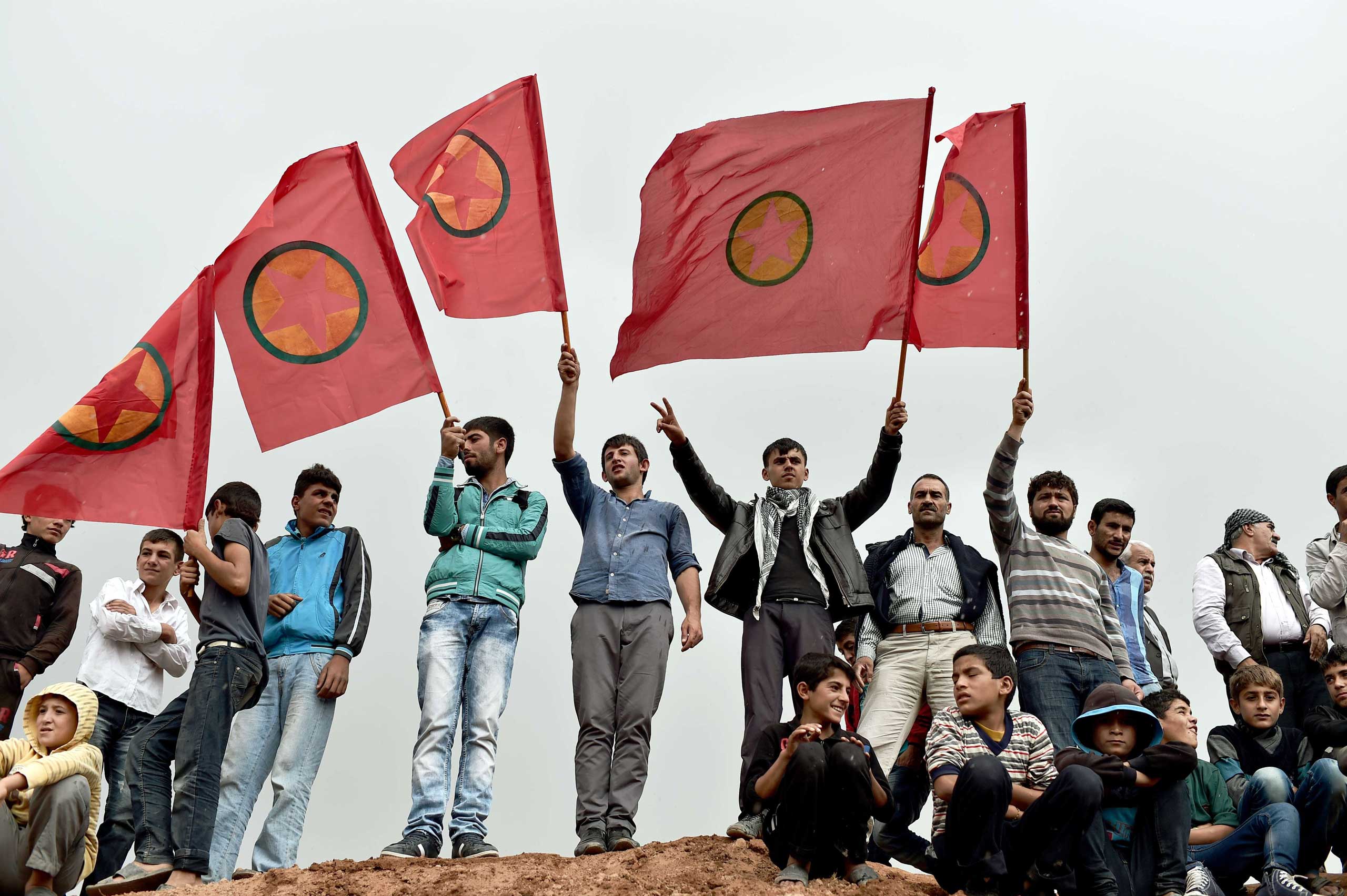 Kurdish people wave Kurdistan Workers' Party (PKK) flags while attending a funeral ceremony for YPG (People's Protection Units) fighters in the town of Suruc, Sanliurfa province, on Oct. 14, 2014. (Aris Messinis—AFP/Getty Images)