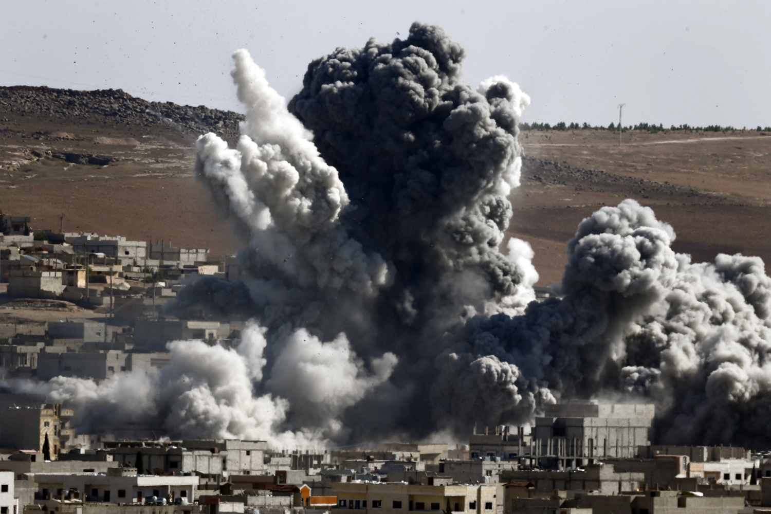 Smoke and dust rise over Syrian town of Kobani after an airstrike on October 22, 2014. (Kai Pfaffenbach —Reuters)