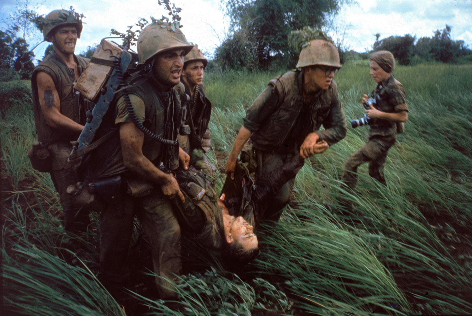 Caption from LIFE. "Four Marines recover the body of a fifth as their company comes under fire near Hill 484." Vietnam, October 1966. NOTE: At right is the French-born photojournalist Catherine Leroy (1945 Ð 2006); she was cropped out of the version of this photo that originally ran in LIFE.