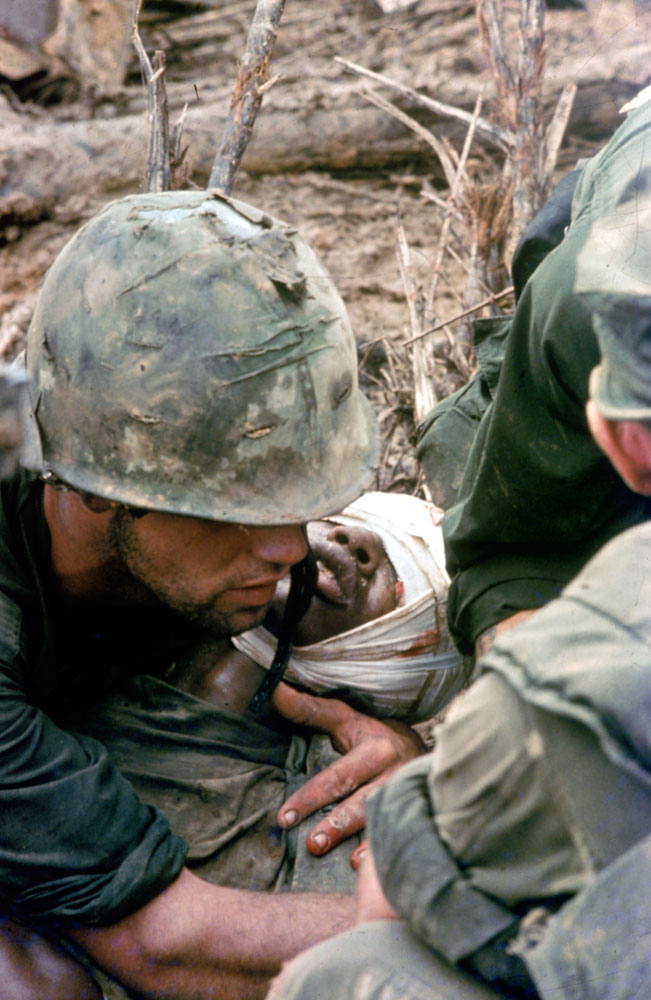 Cover image, LIFE magazine. American Marines aid a wounded comrade during Operation Prairie near the DMZ during the Vietnam War, October 1966.