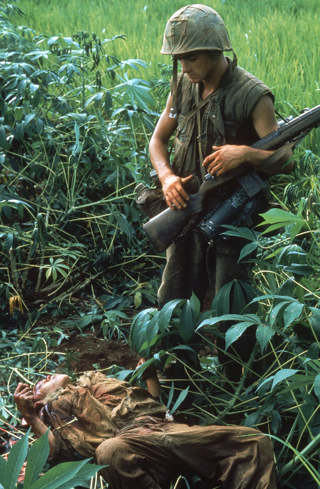Not published in LIFE. An American Marine looks at the body of a North Vietnamese killed during Operation Prairie near the DMZ during the Vietnam War, October 1966.
