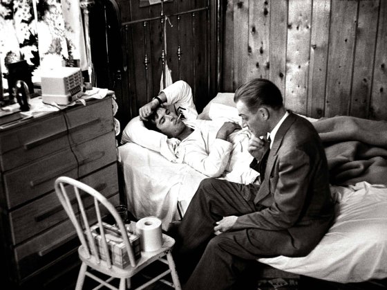 Dr. Ceriani sits at bedside of a patient as he assesses flu symptoms during a house call. When Smith began 