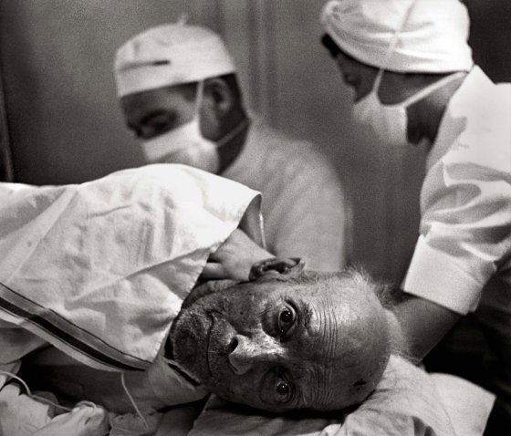 Dr. Ceriani gives the 85-year-old man spinal anesthesia before amputating his gangrenous left leg.