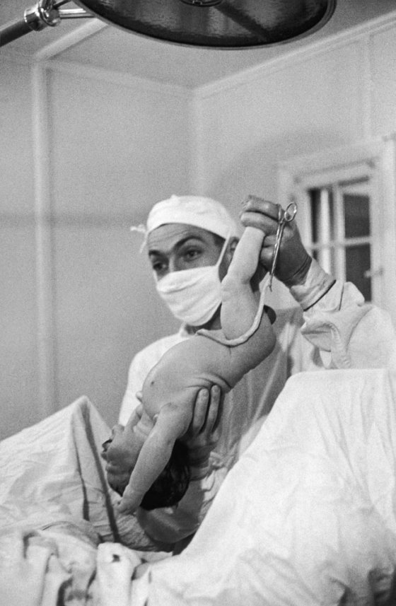 Not published in LIFE. Dr. Ernest Ceriani delivers a baby.