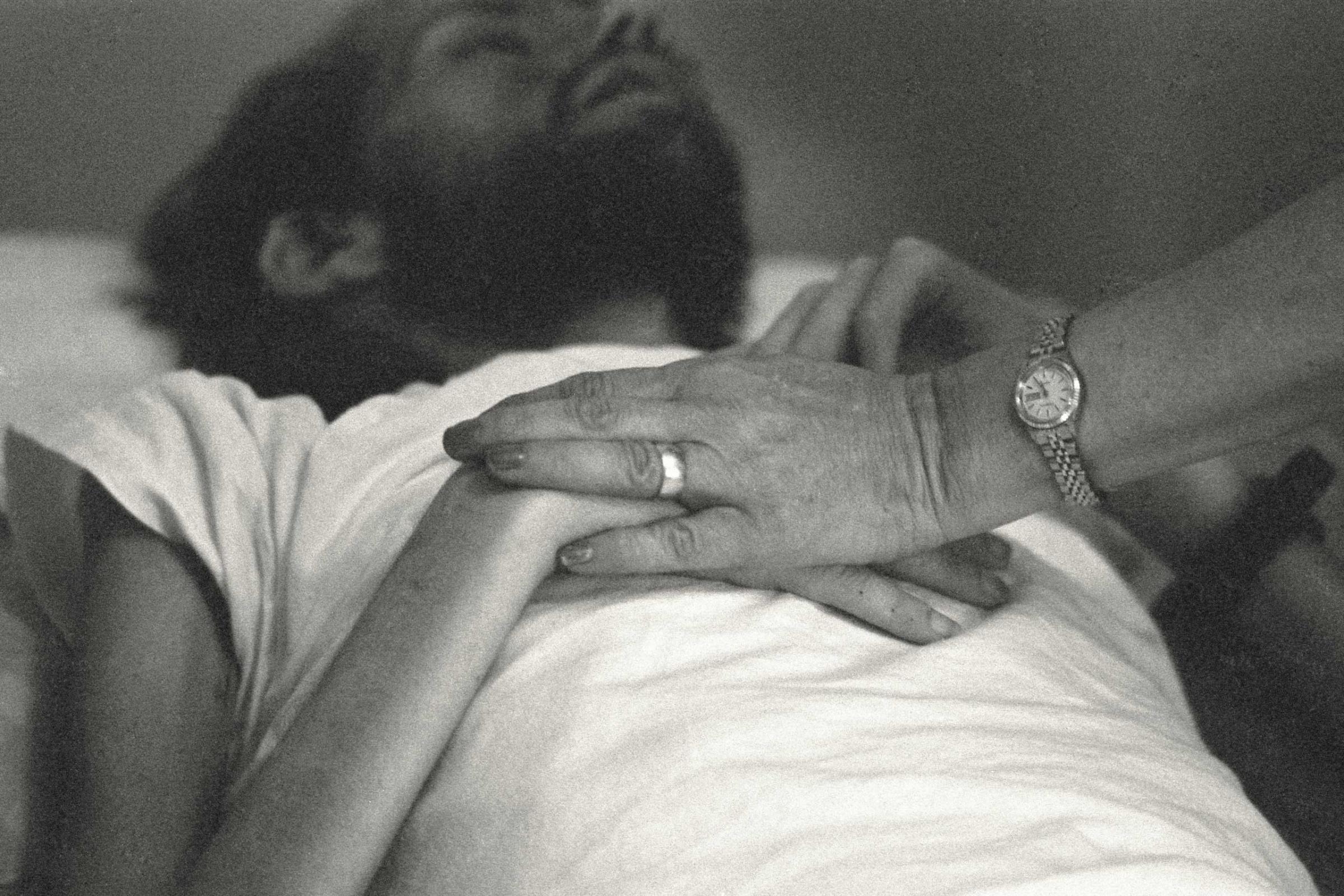 A nurse at Pater Noster House in Ohio holds David Kirby's hands not long before he died, spring 1990.