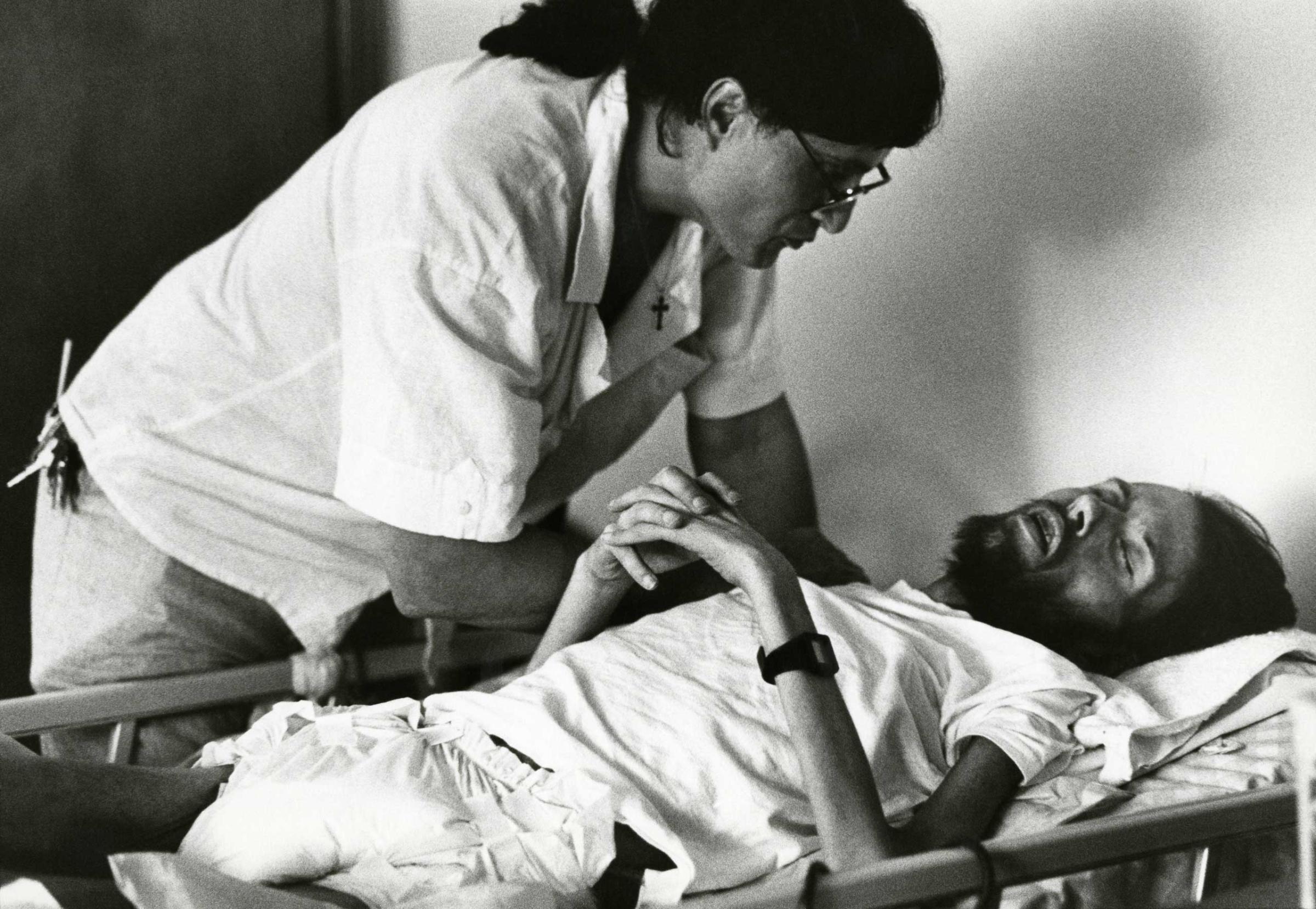 Peta, a volunteer at Pater Noster House in Ohio, cares for a dying David Kirby, 1990.