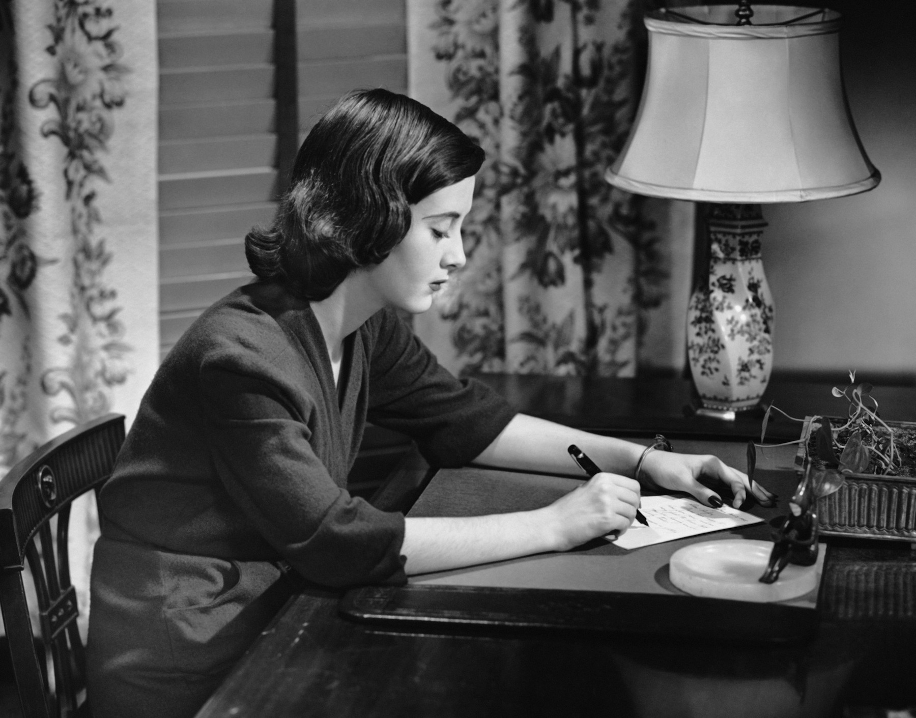Portrait of woman writing letter at desk, circa 1950 (George Marks—Getty Images)