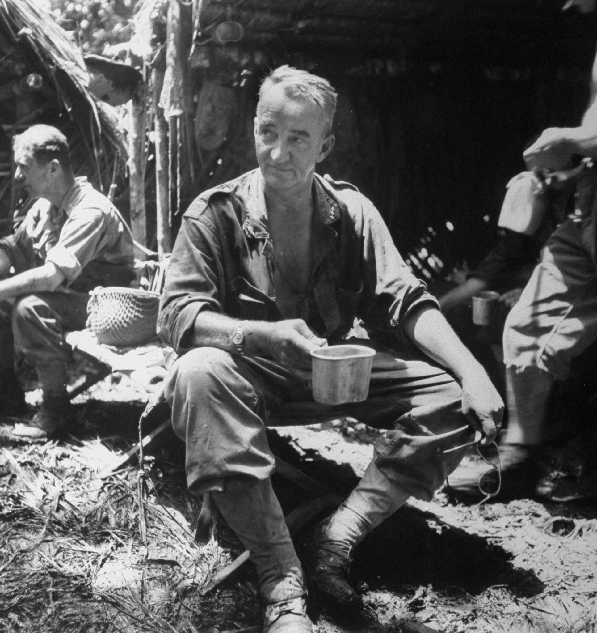 "At a medical collecting station Gen. Eichelberger stops for tea. Soon he was on his way again, walking toward the Buna front through mud to his knees."