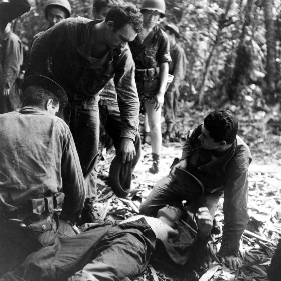 A soldier with fever is aided by fellow soldiers, Buna, New Guinea Campaign, WWII.